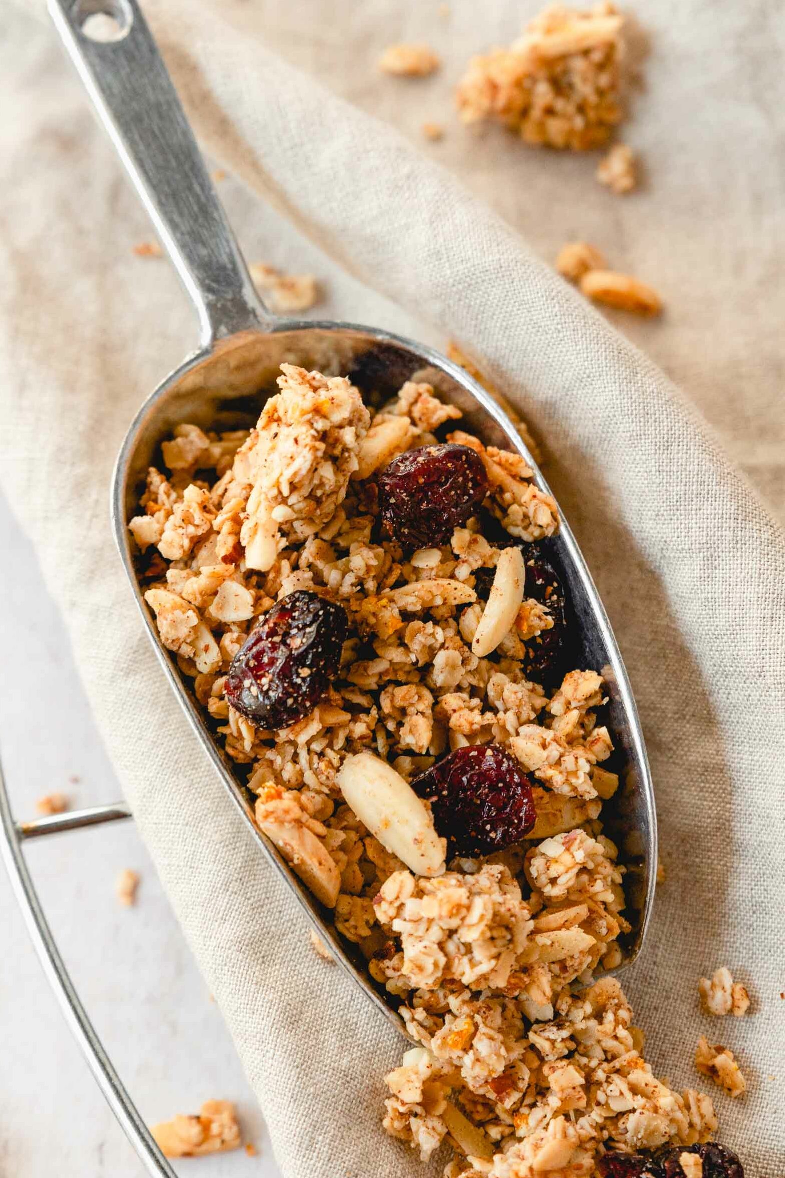 christmas spiced granola with cranberries on vintage serving spoon on beige background.