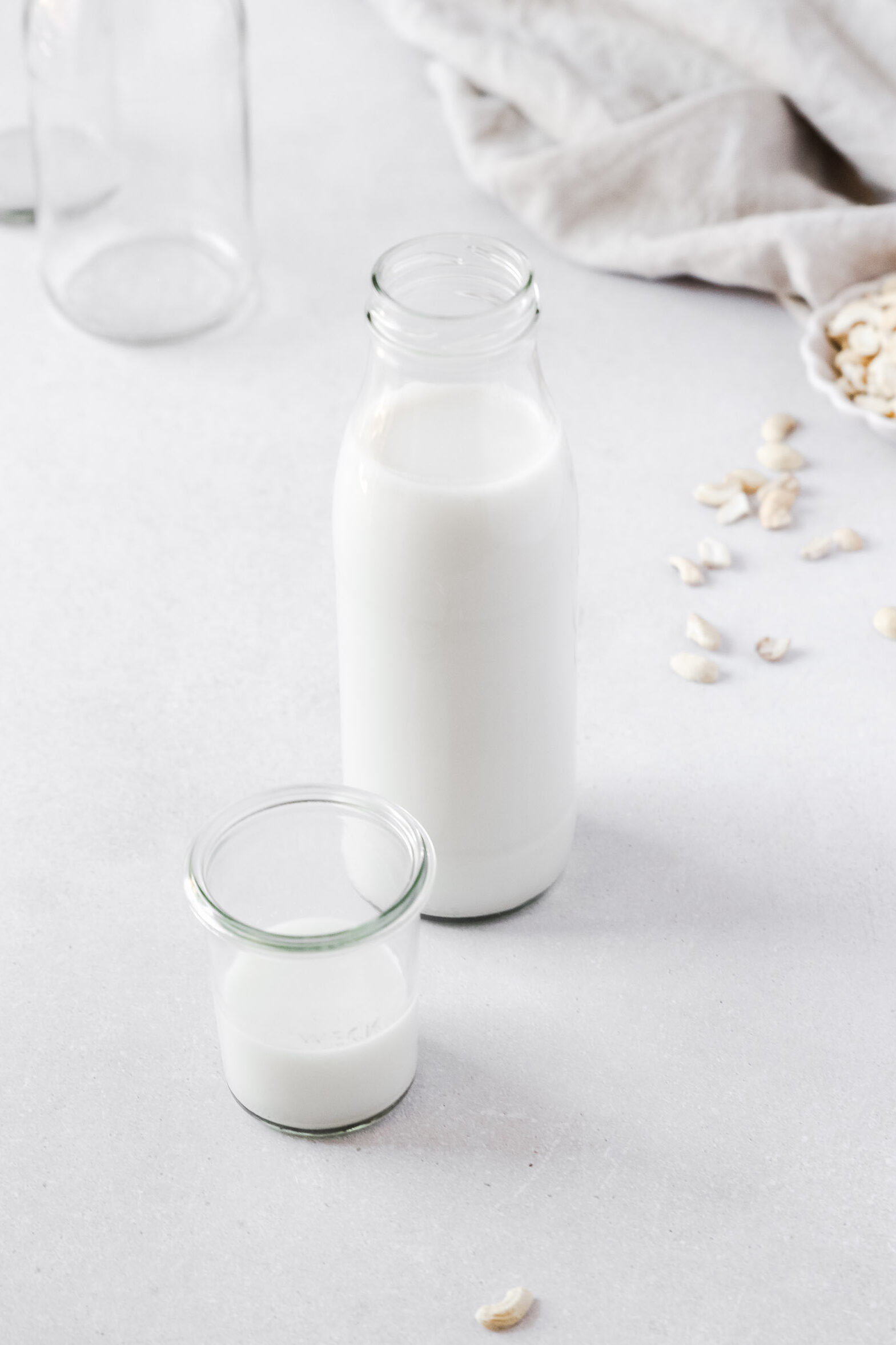 Nut milk bottle and weck jar on white background