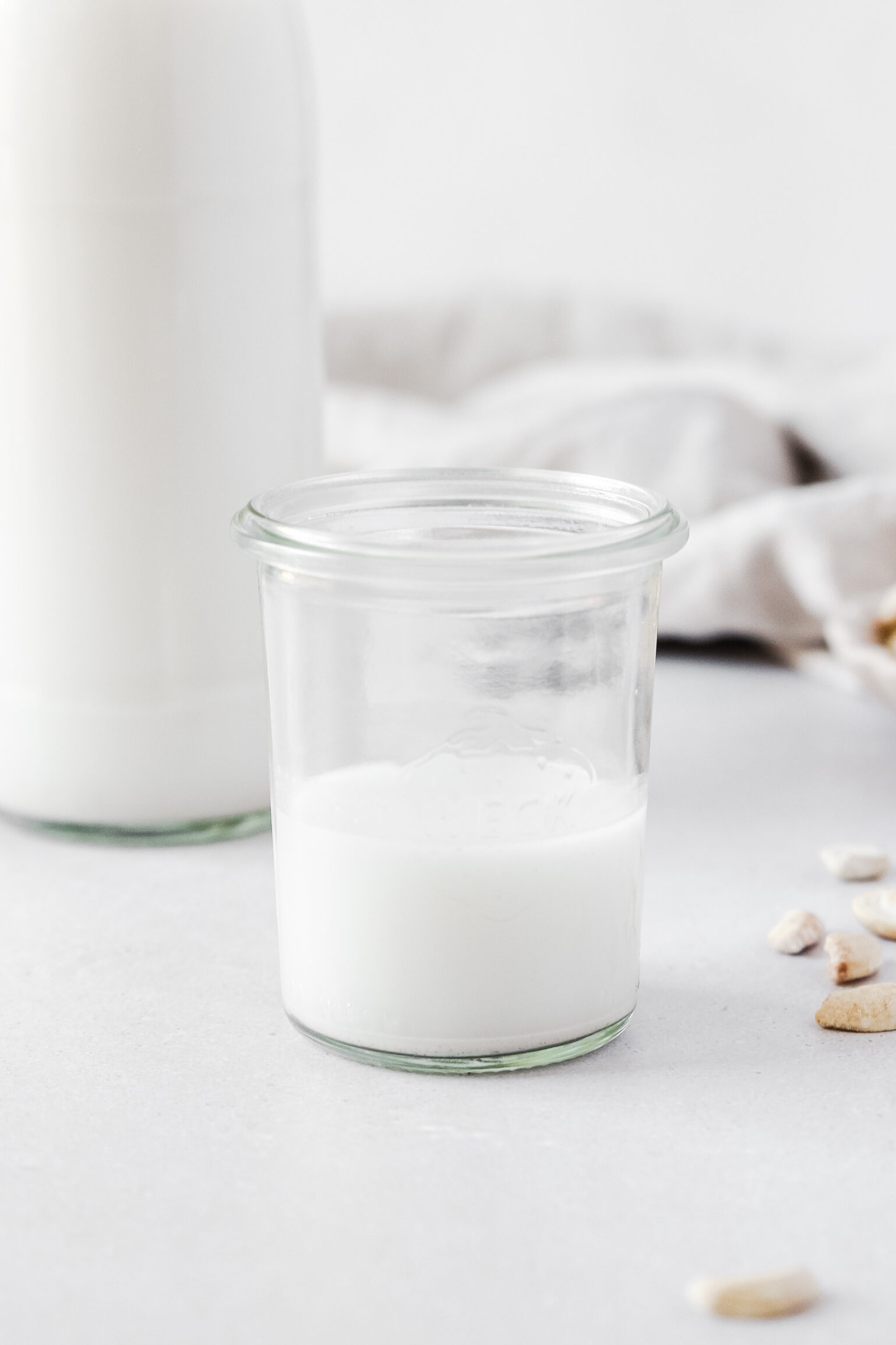 Nut milk bottle and weck jar on white background