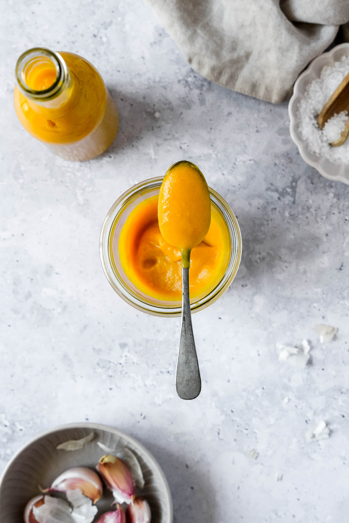 vibrant and spicy mango sauce in weck jar with vintage spoon on grey blue background