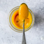 vibrant and spicy mango sauce in weck jar with vintage spoon on grey blue background