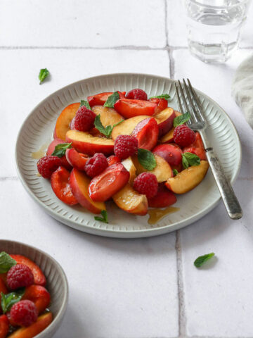 different stone fruits on grey plate with vintage fork