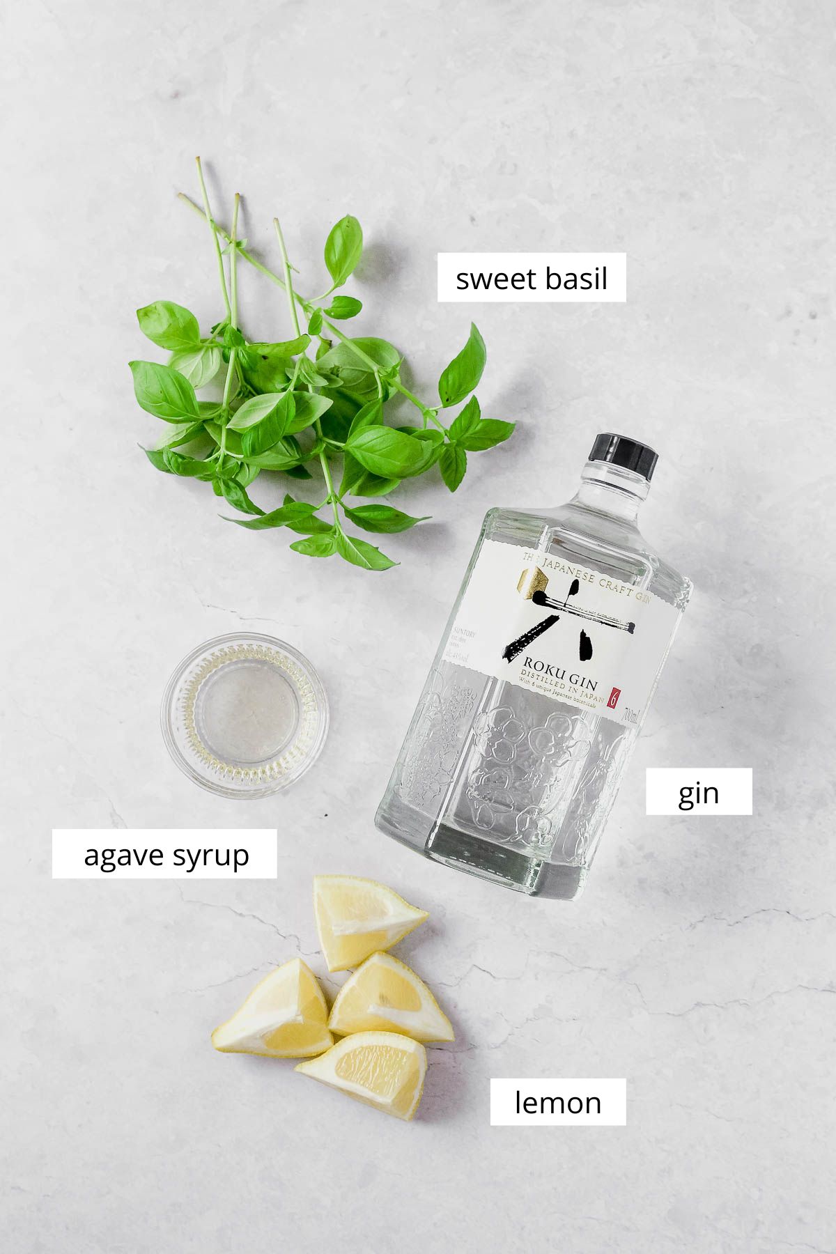 ingredients for gin basil smash on grey marble background.