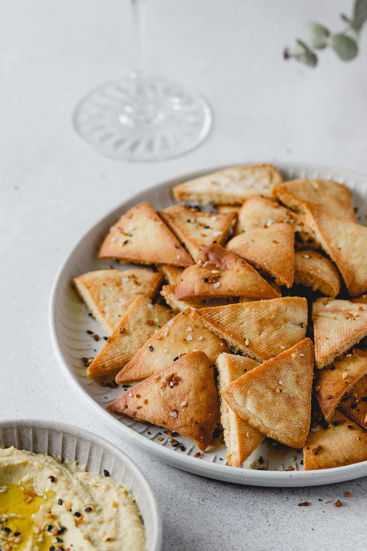 homemade pita chips with everything bagel seasoning on grey plate with hummus