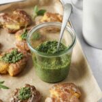 thai basil pesto in weck jar on baking sheet with smashed potatoes.