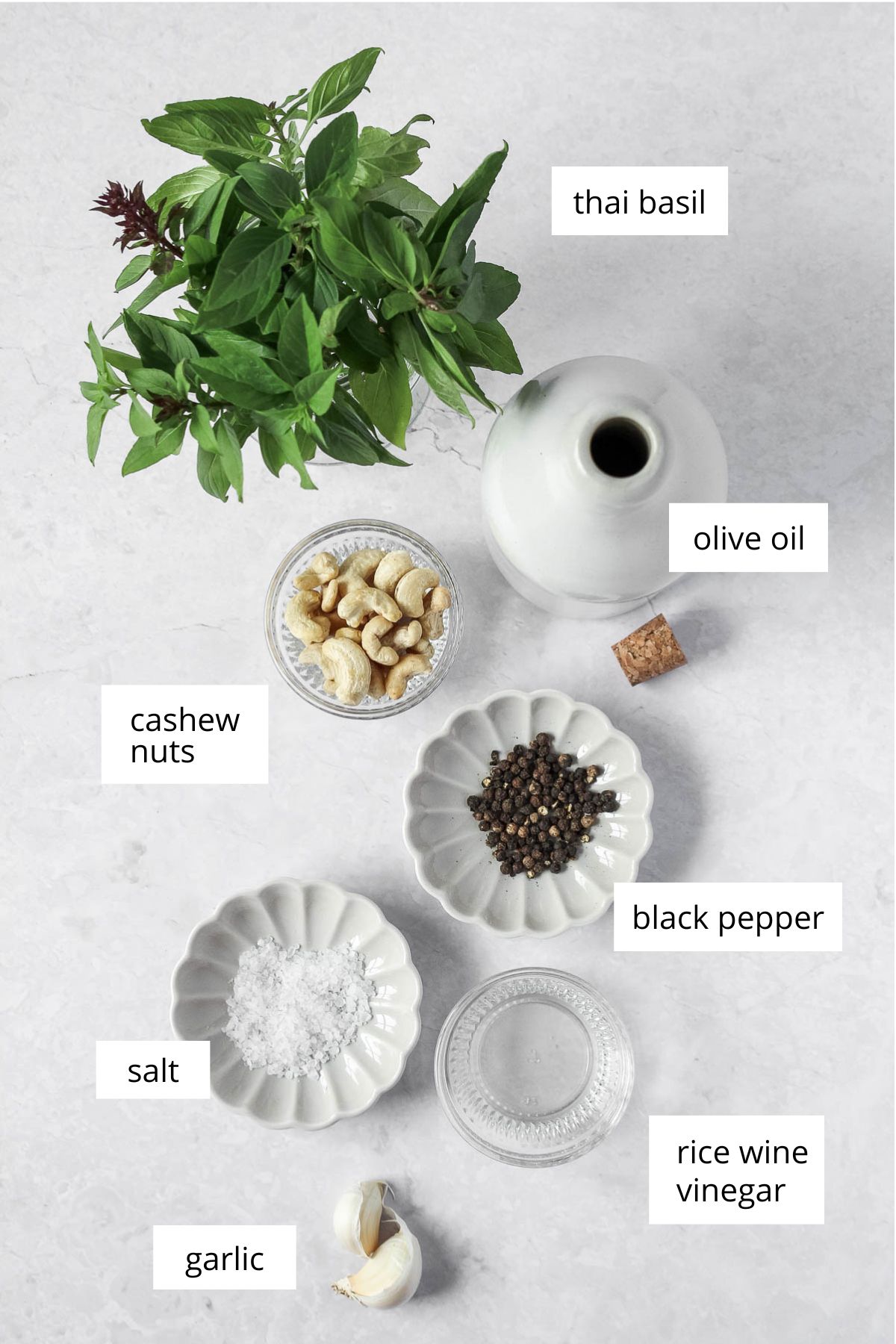 ingredients for thai basil pesto on white marble background.