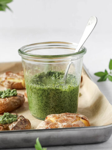 thai basil pesto in weck jar on baking sheet with smashed potatoes.