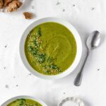 easy vegan broccoli soup with vintage spoon on white background.