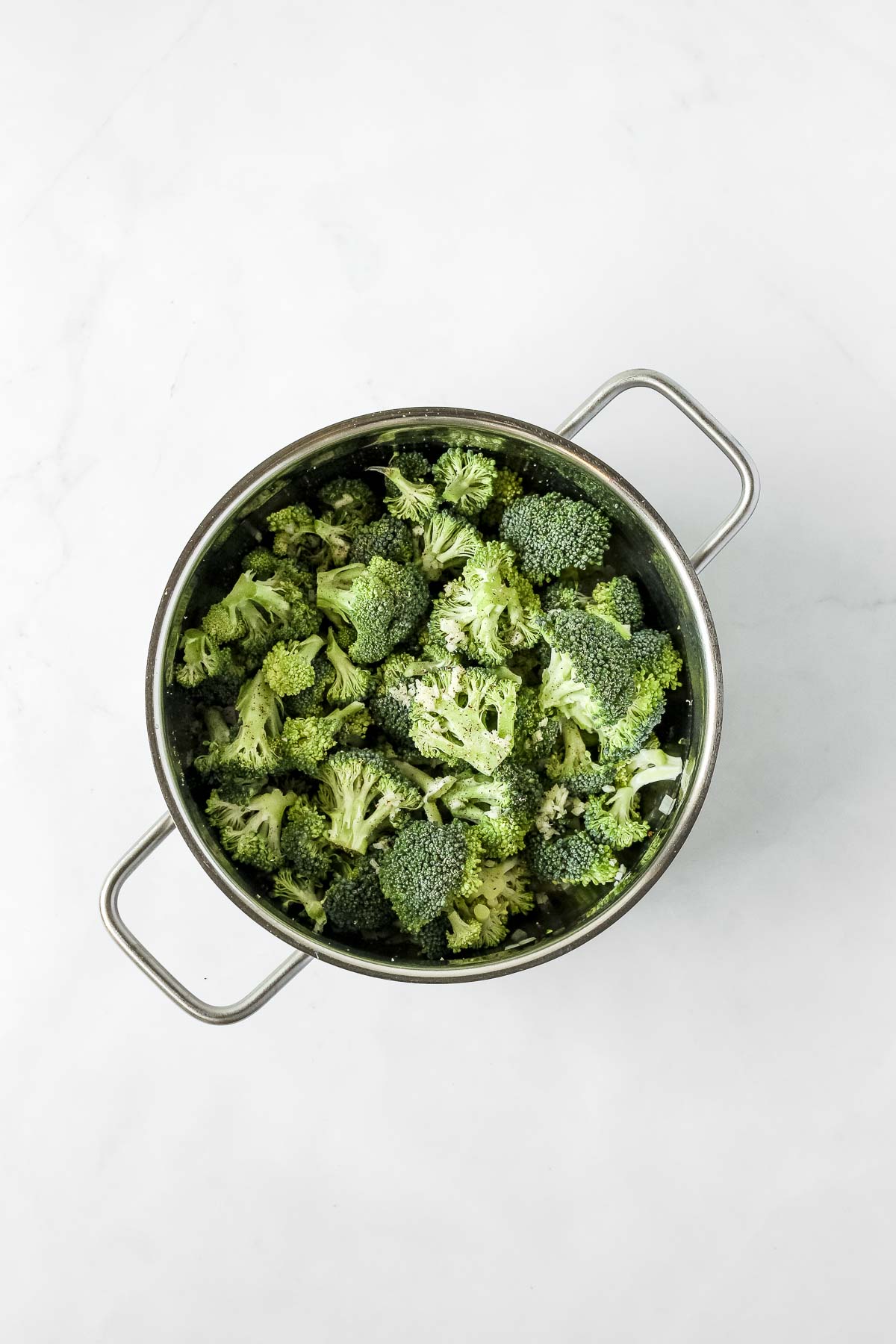 broccoli, onion, garlic and spices in pot.