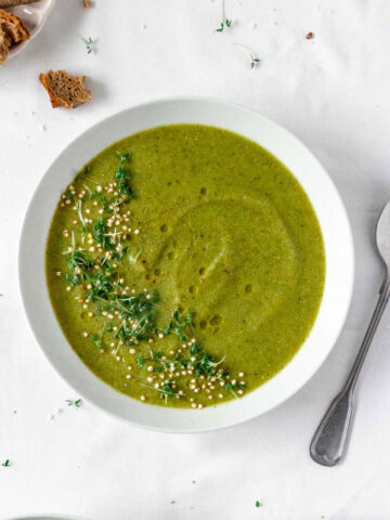 vegan cream of broccoli soup with vintage spoon on white background.