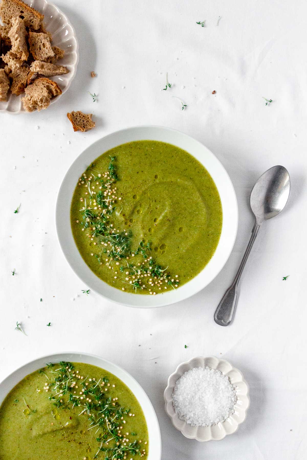 vegan broccoli soup with vintage spoon on white background.