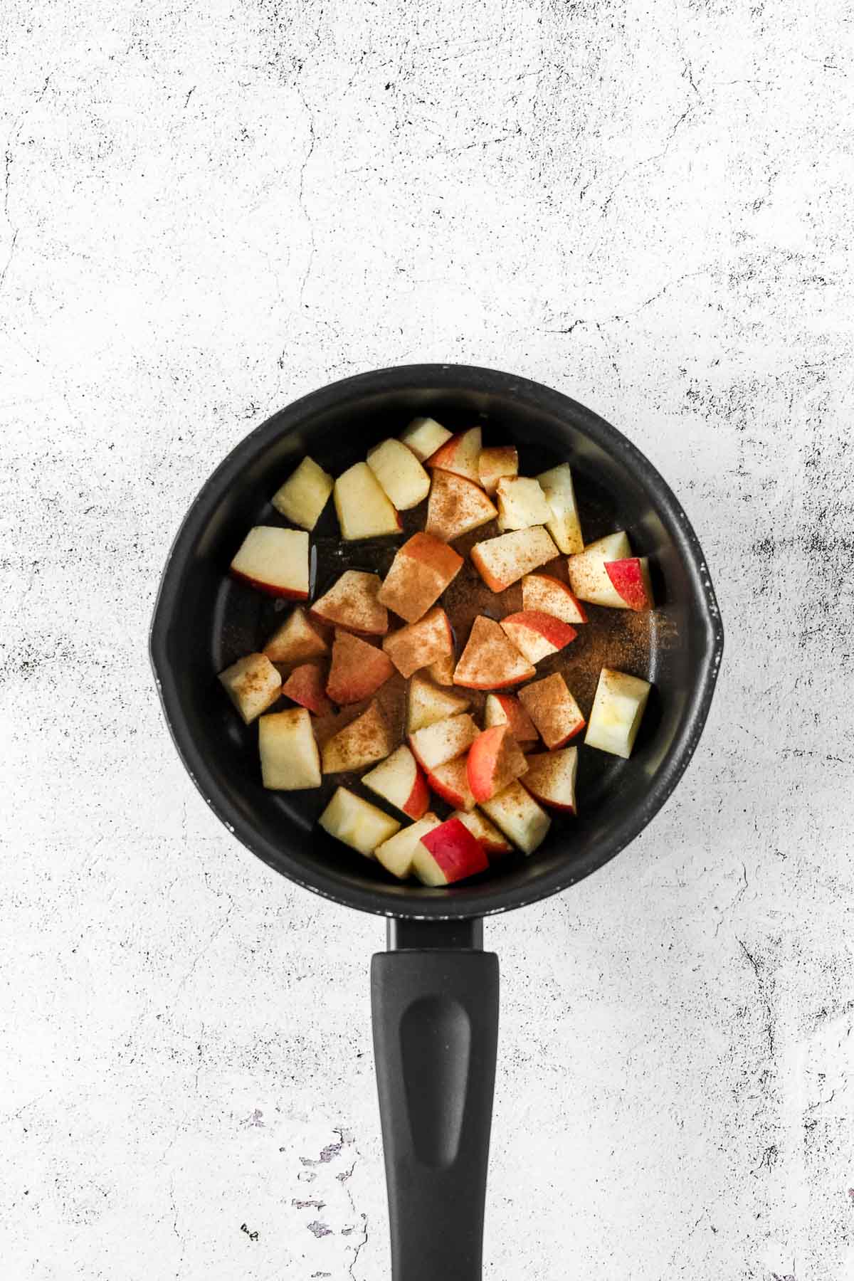 honey, apples and cinnamon powder in pot ready to cook.