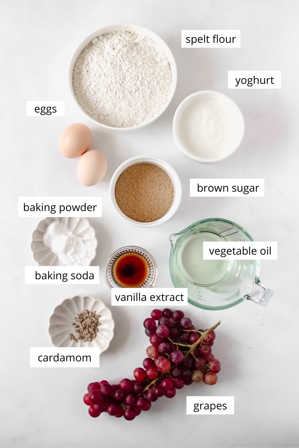 ingredients for grape cake on white background.