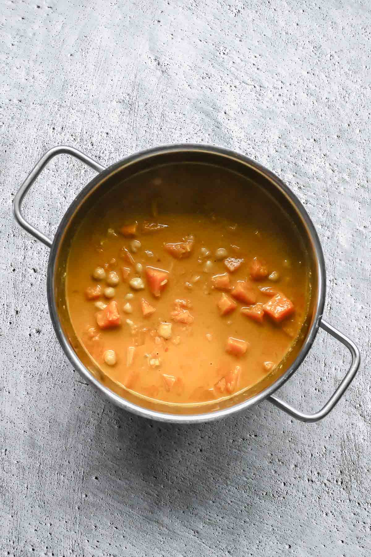 cooked butternut squash curry ii pot on grey background.