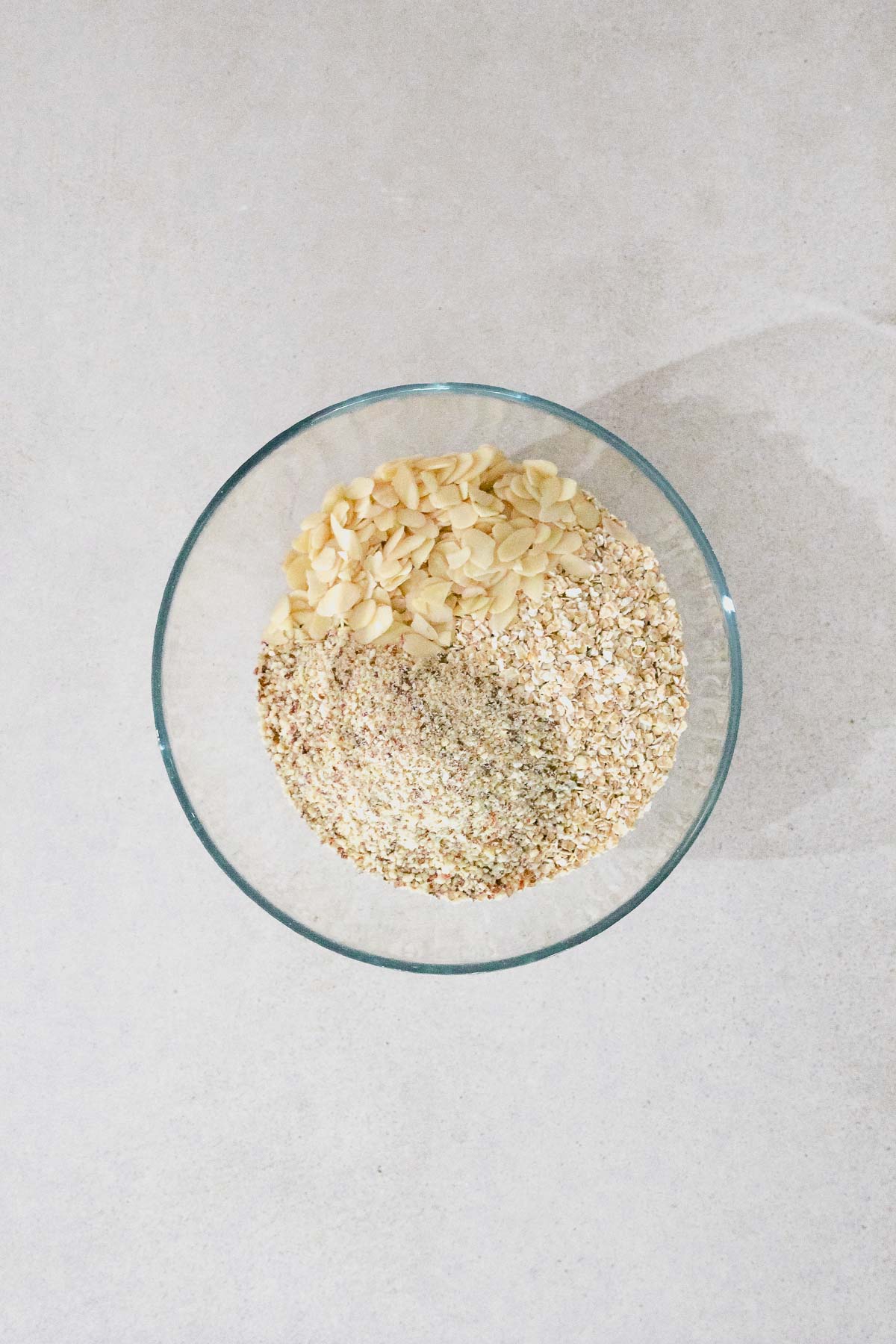 ingredients for almond granola in a glass bowl.