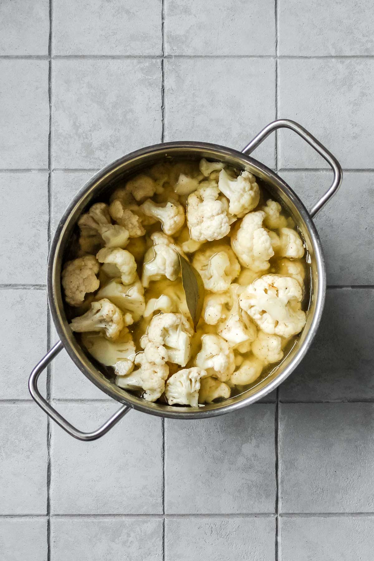 cauliflower, onion, garlic, vegetable stock and spices in pot.