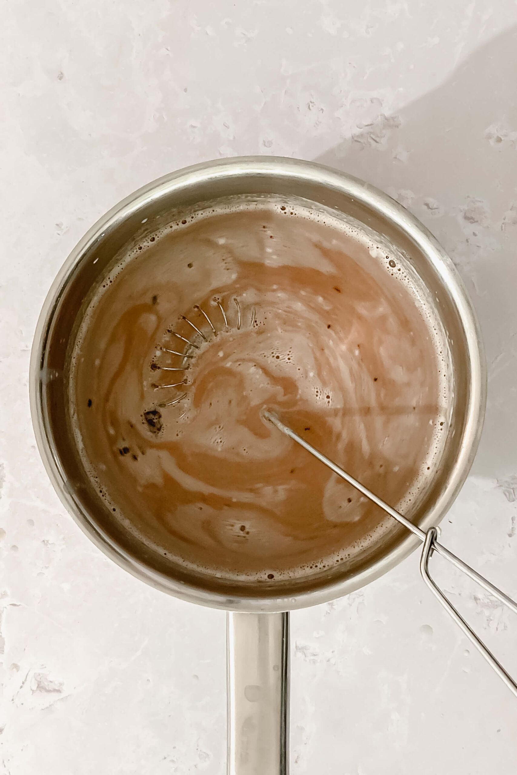 whisking ingredients for hot chocolate in small saucepan.