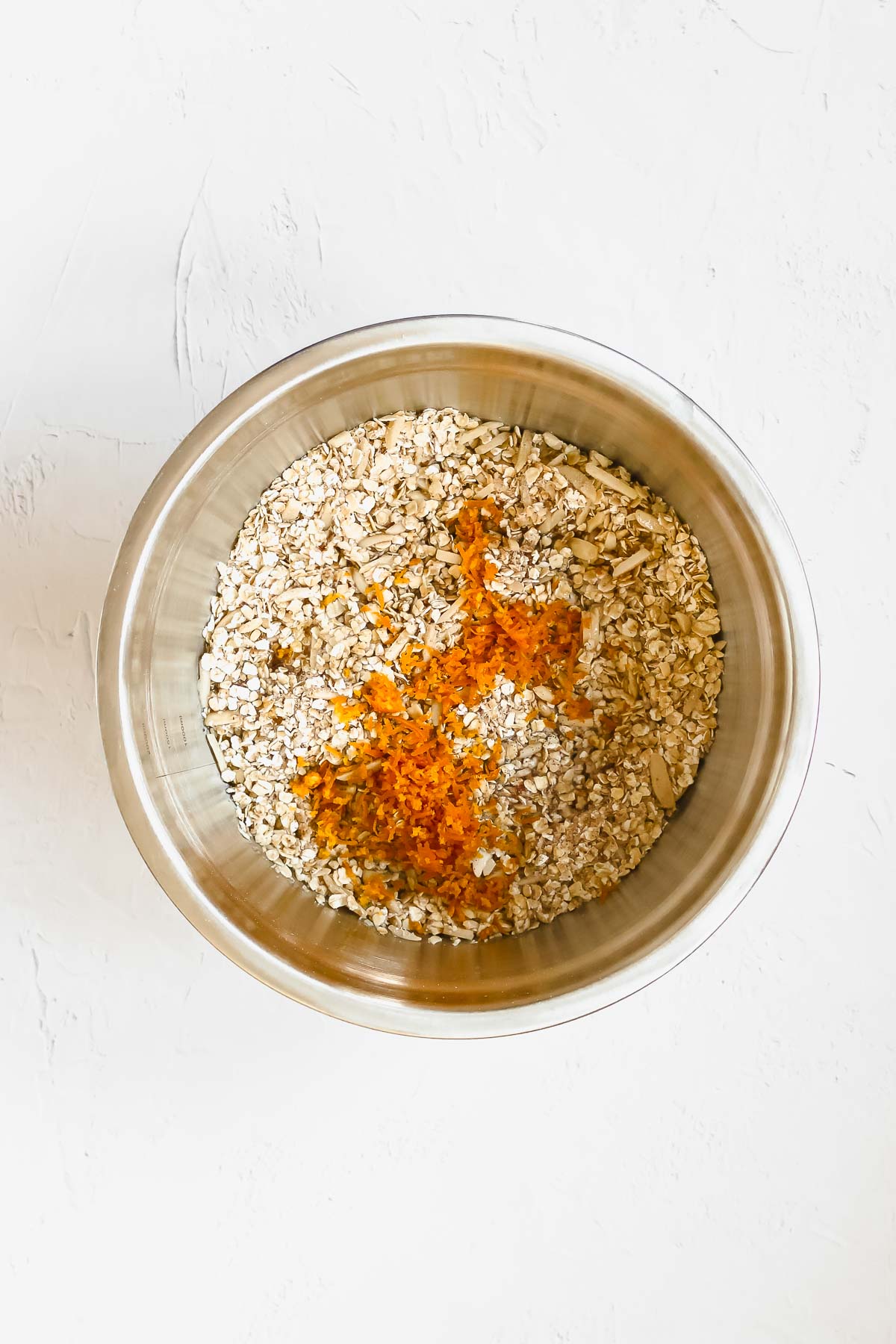 ingredients for gingerbread granola in metal bowl.