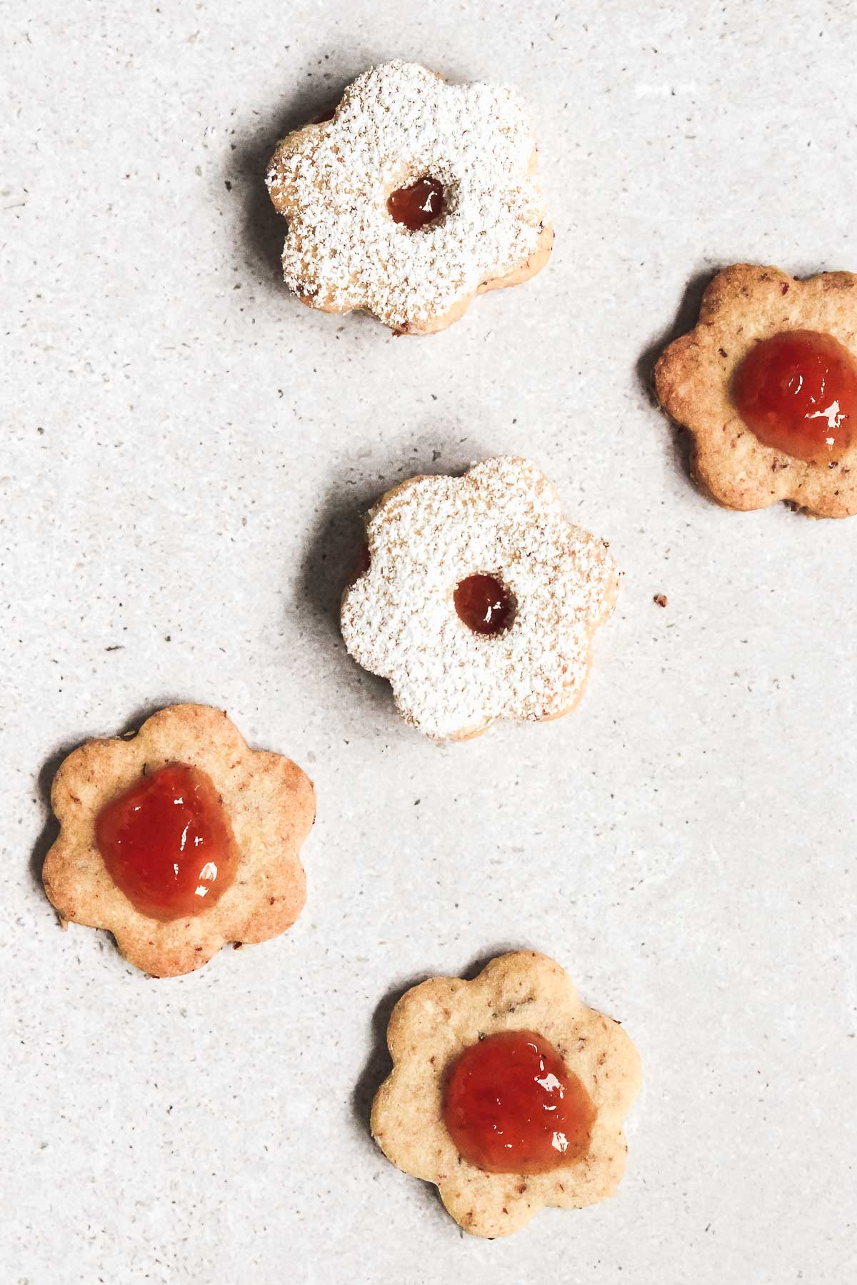 linzer cookies with apricot jam on grey background.