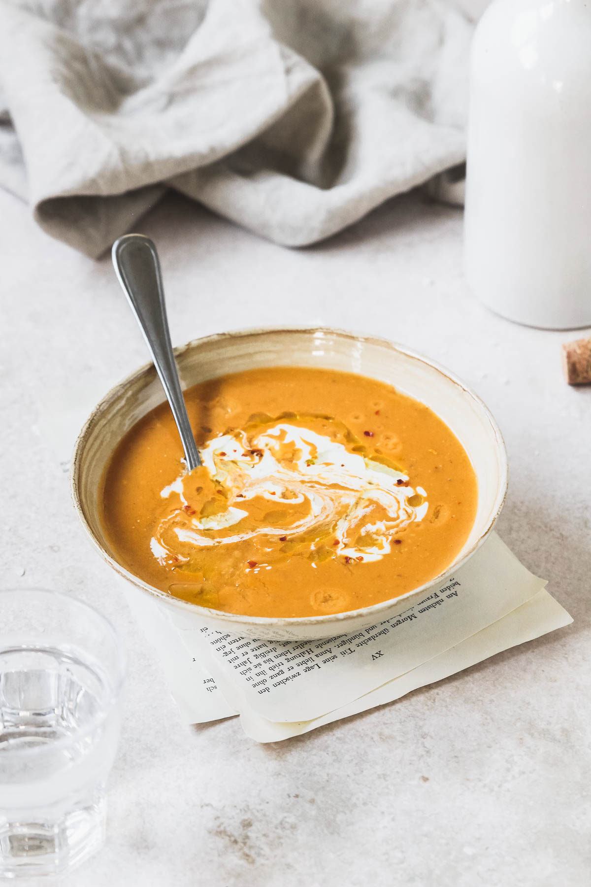 mediterranean lentil soup in beige bowl with vintage spoon on vintage grey background.