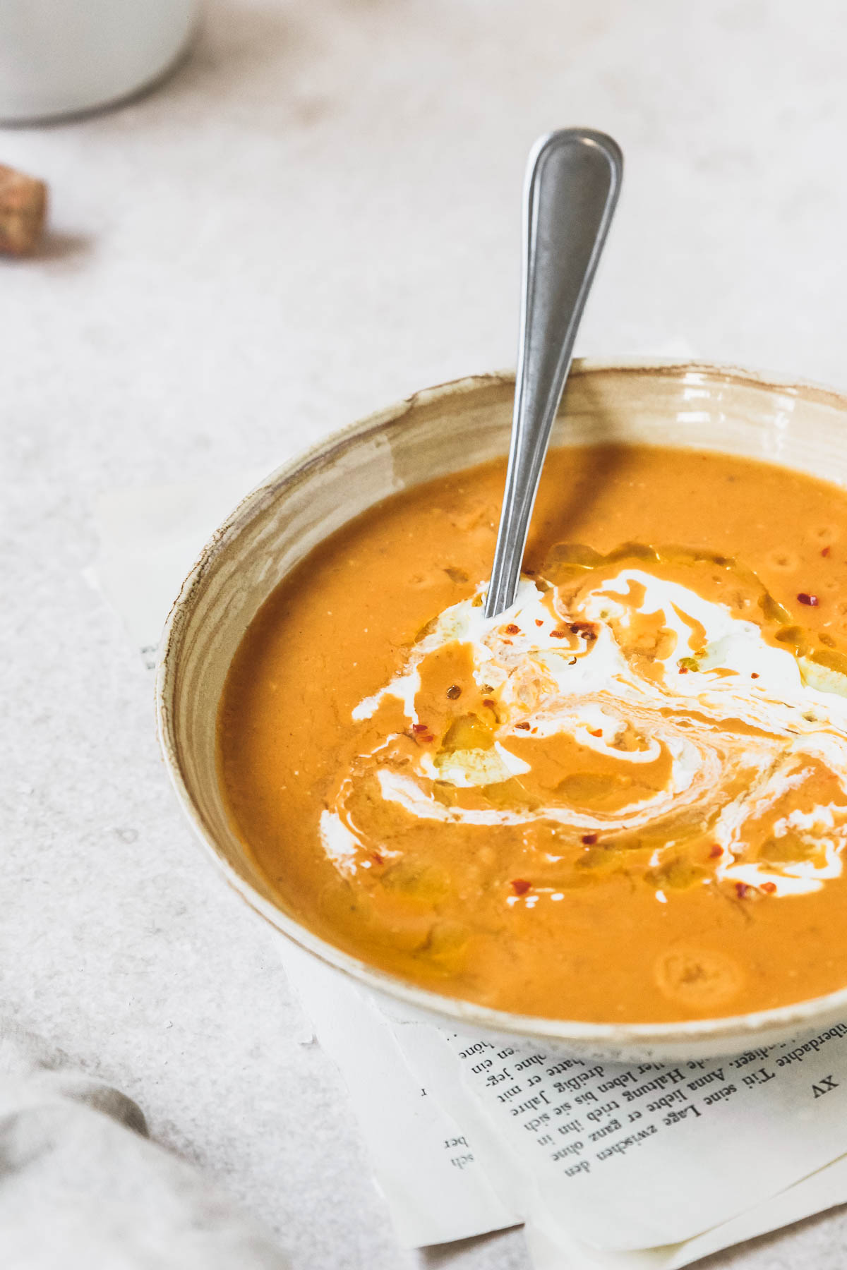 creamy lentil soup in bowl with vintage spoon on vintage beige background with props.