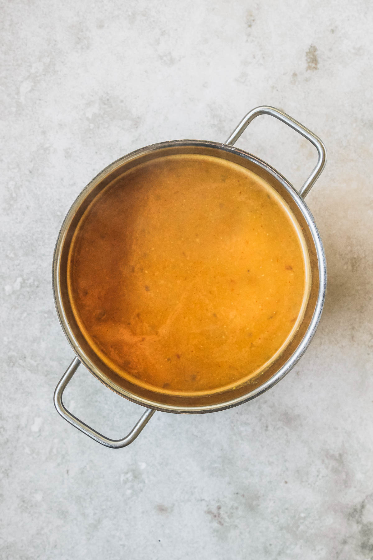 pot with pureed lentil soup on vintage beige background.