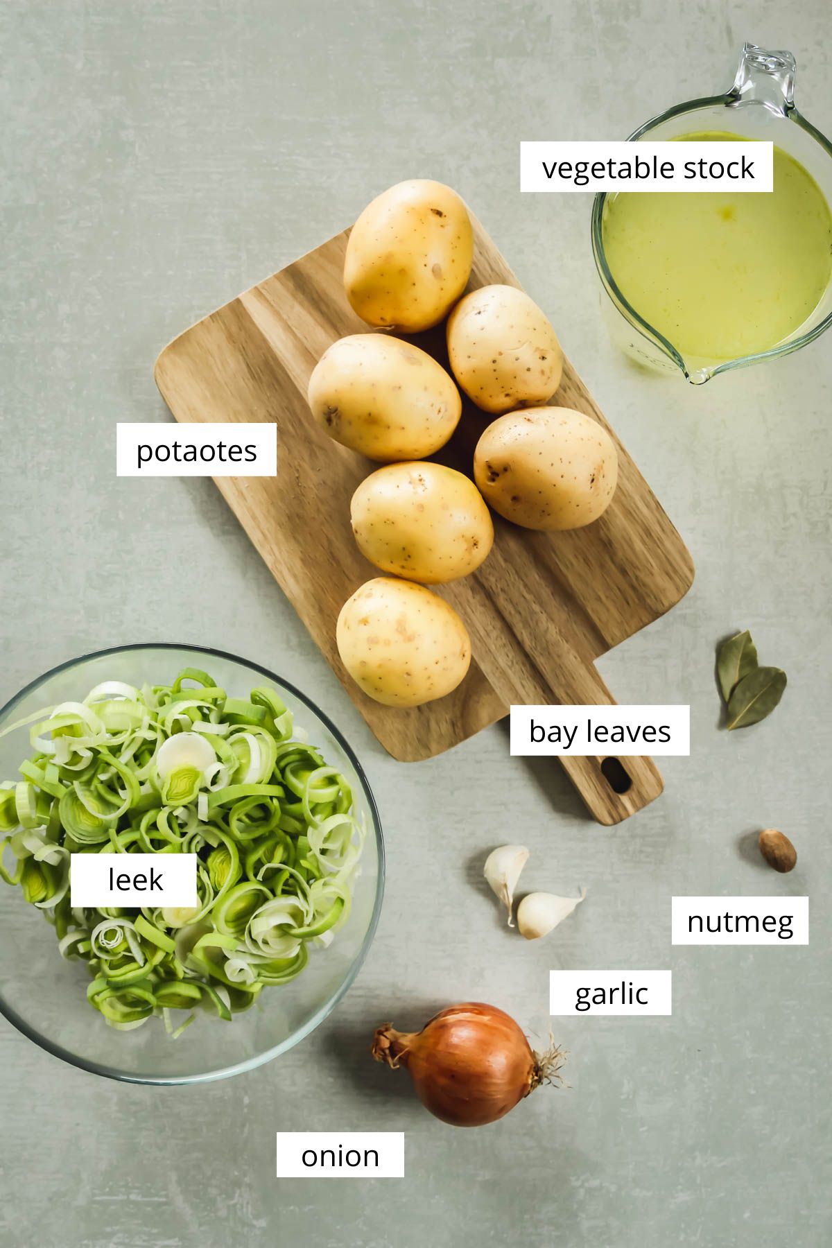 ingredients for potato and leek soup on green background.