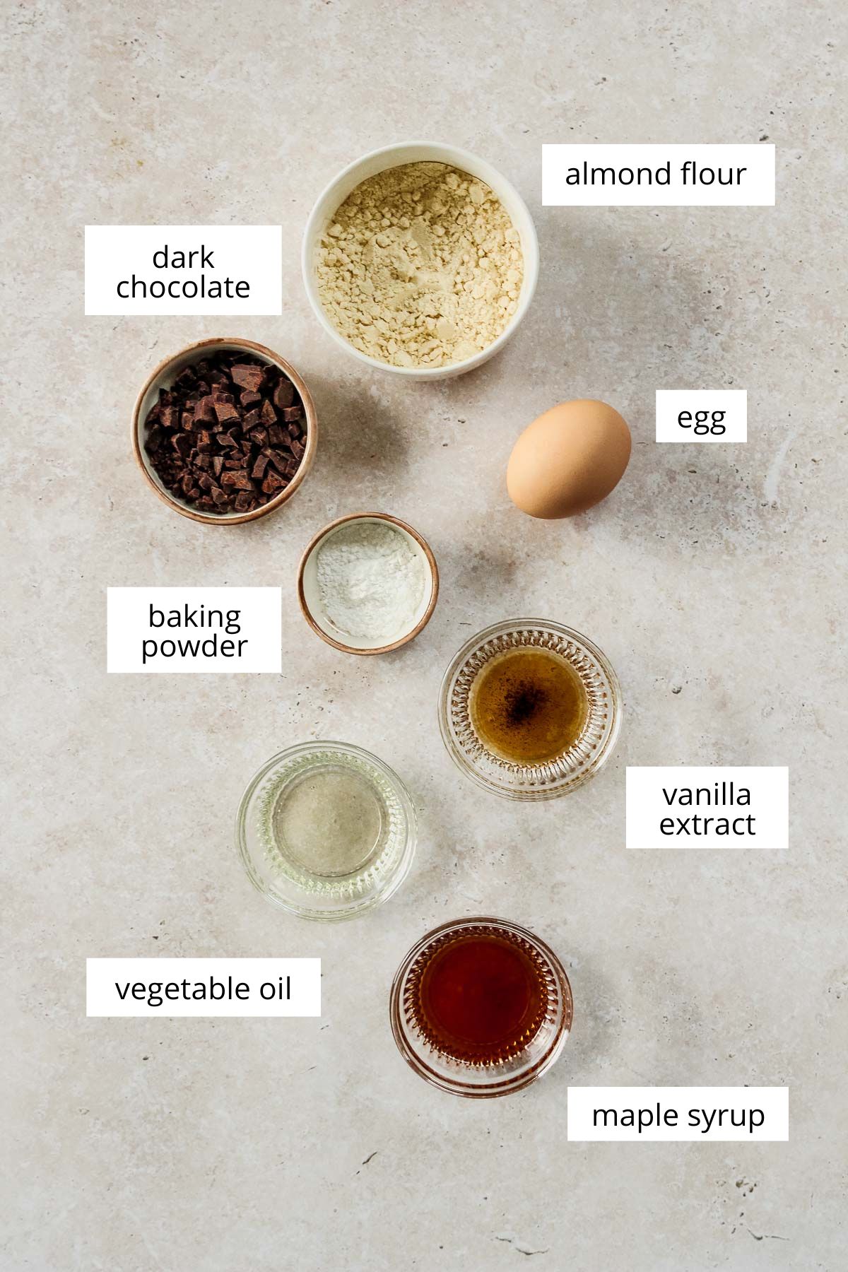 ingredients for healthy chocolate chip mug cake on beige marble background.