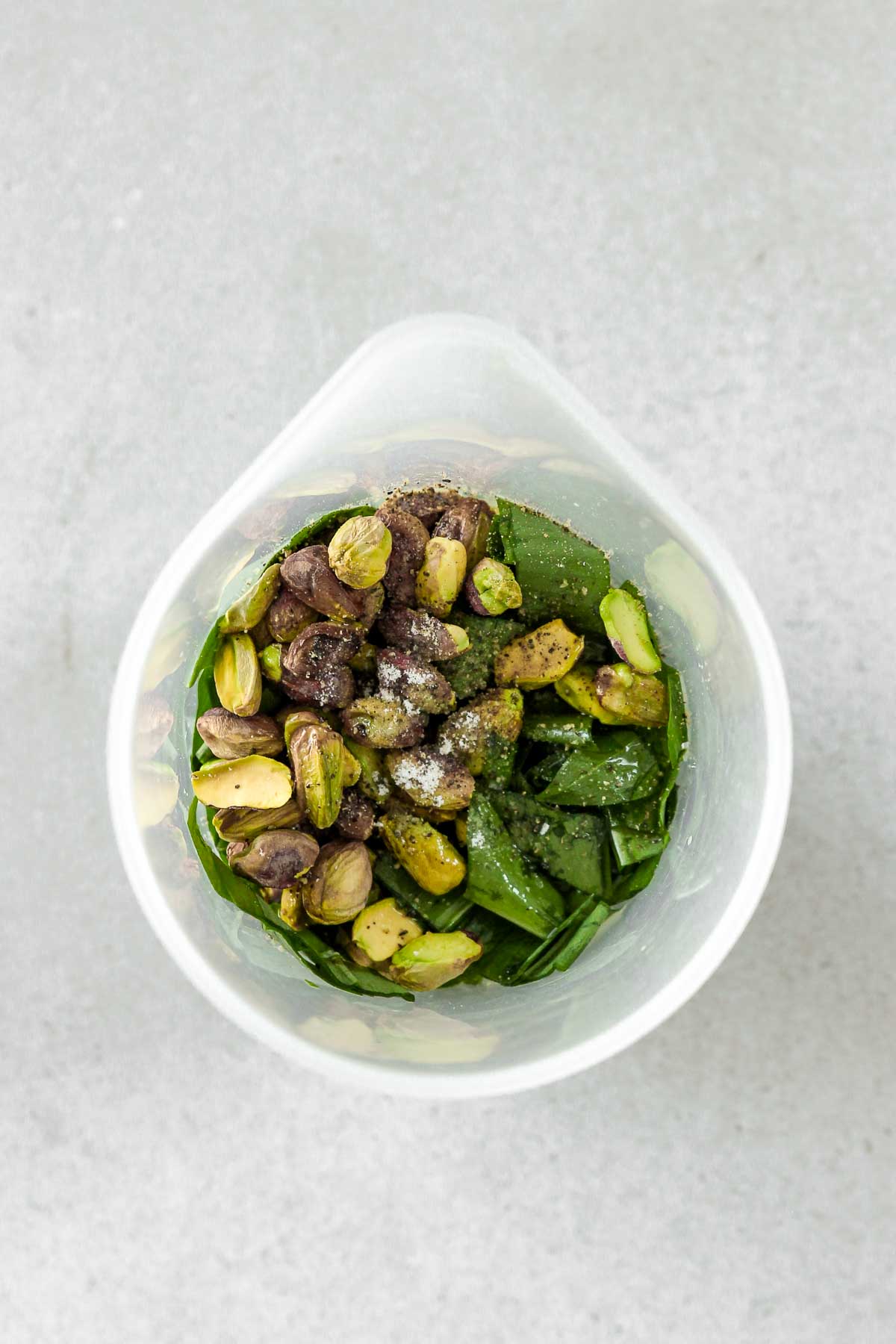 ingredients for vegan wild garlic pesto in a cup before pureeing.