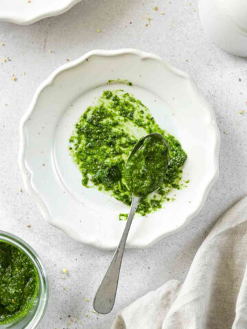 wild garlic pistachio pesto on a beige plate with a vintage spoon.