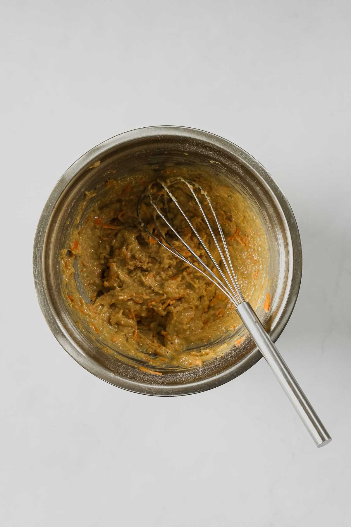 mixed carrot cake cupcakes dough in a metal bowl.