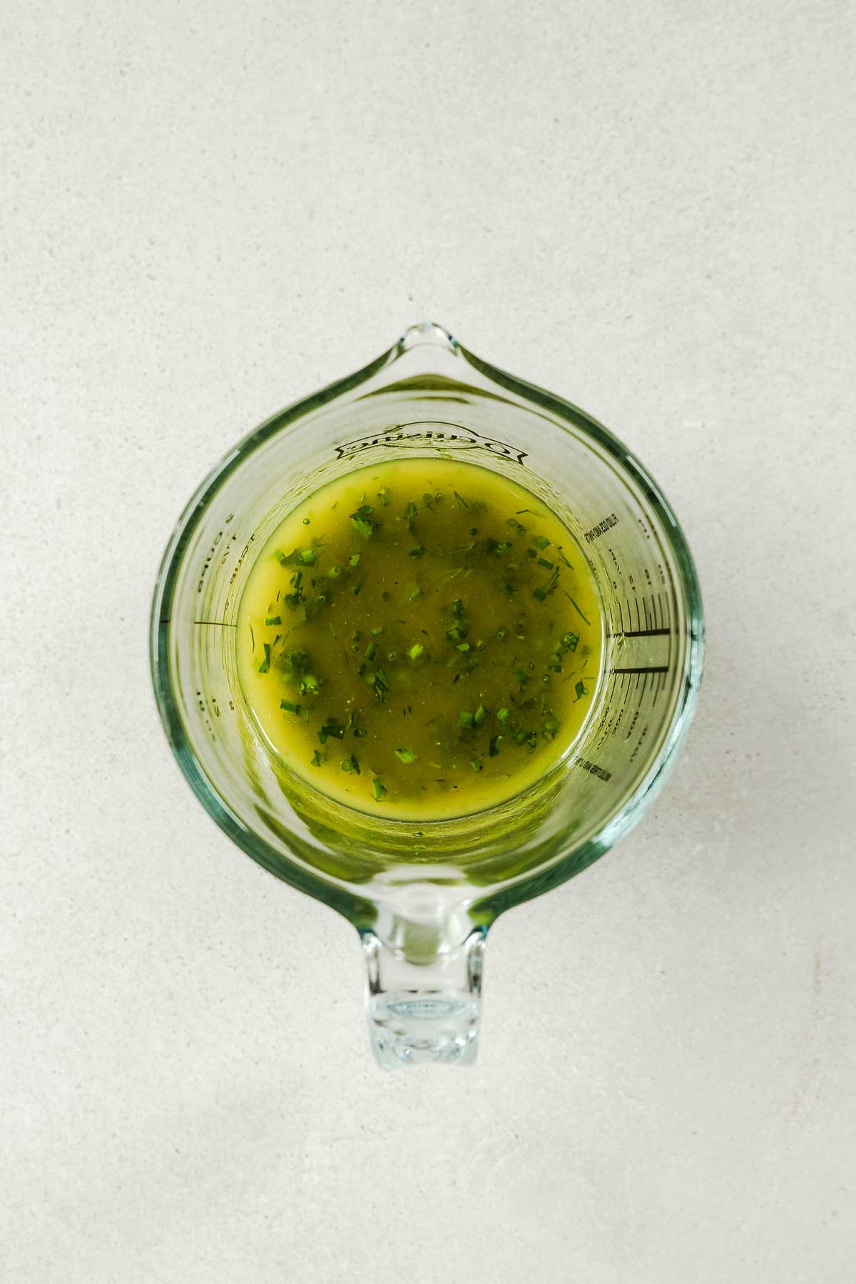 lemon herb dressing in a measuring cup.