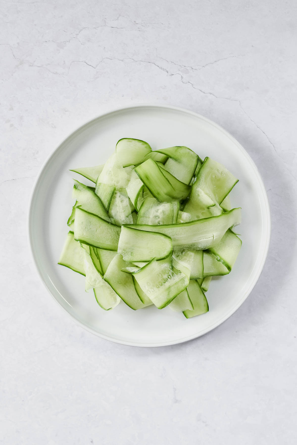 sliced cucumber on white plate.