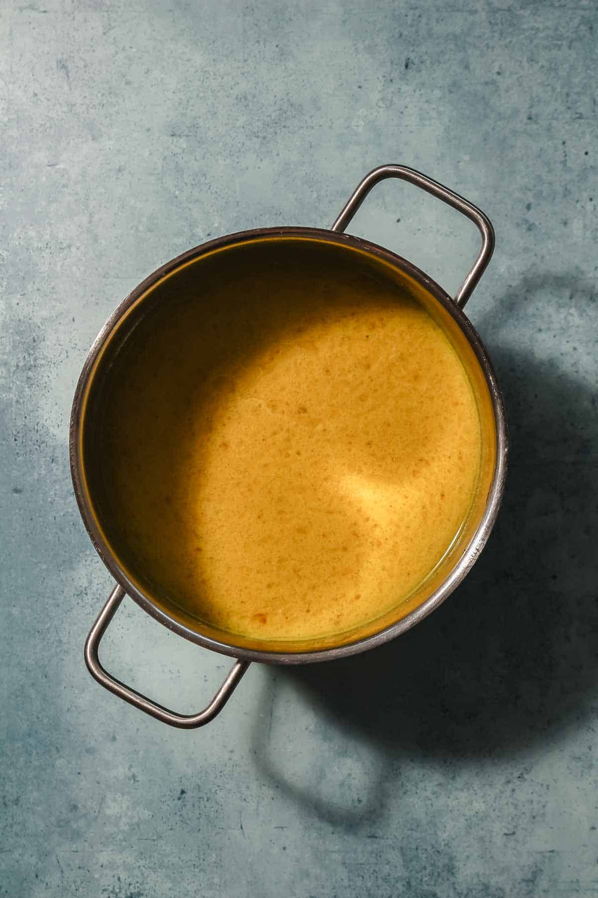 base for yellow vegetable curry with coconut milk in pot.