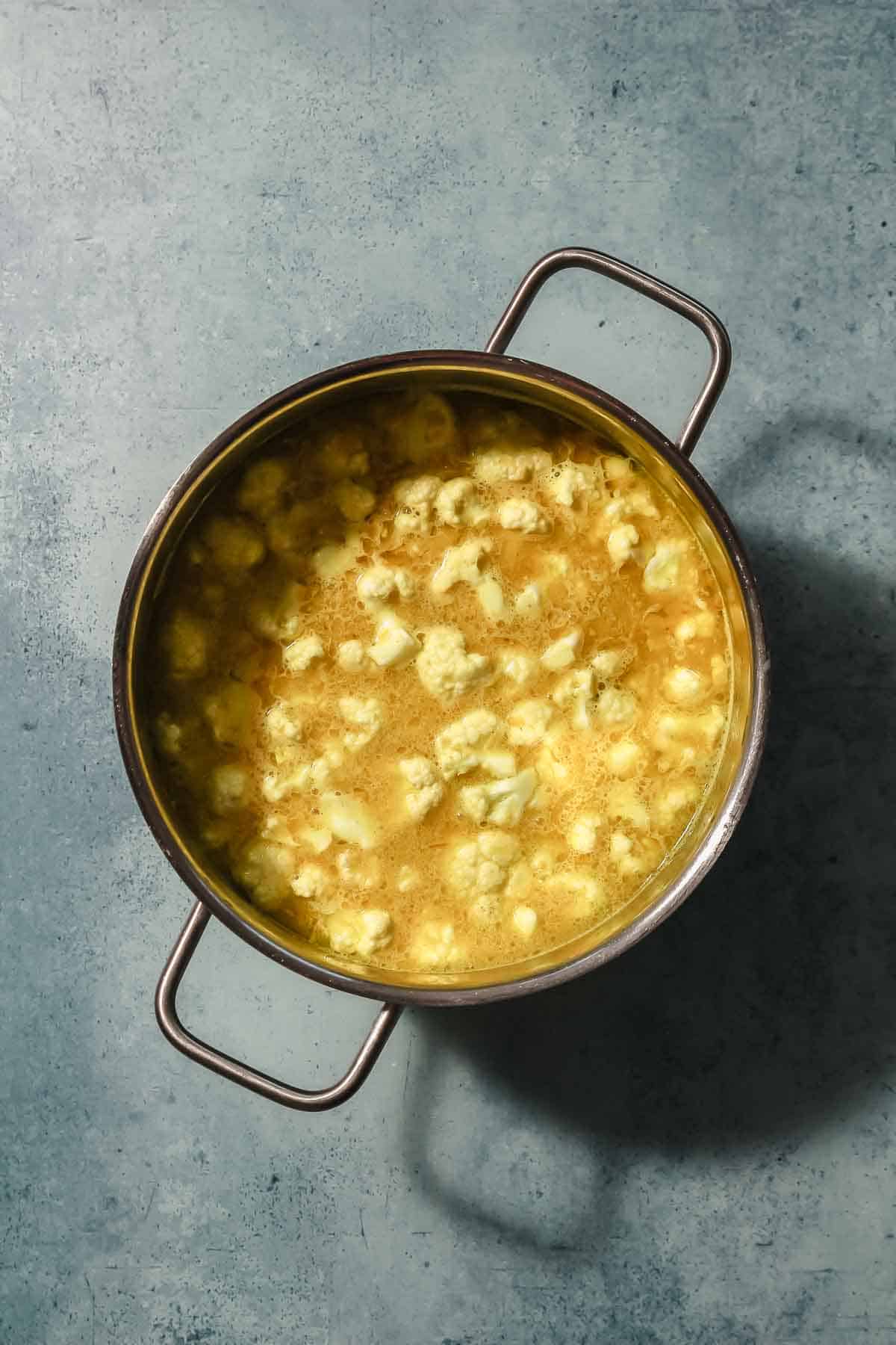 cauliflower florets simmering in spices and coconut milk for creamy vegetable curry.