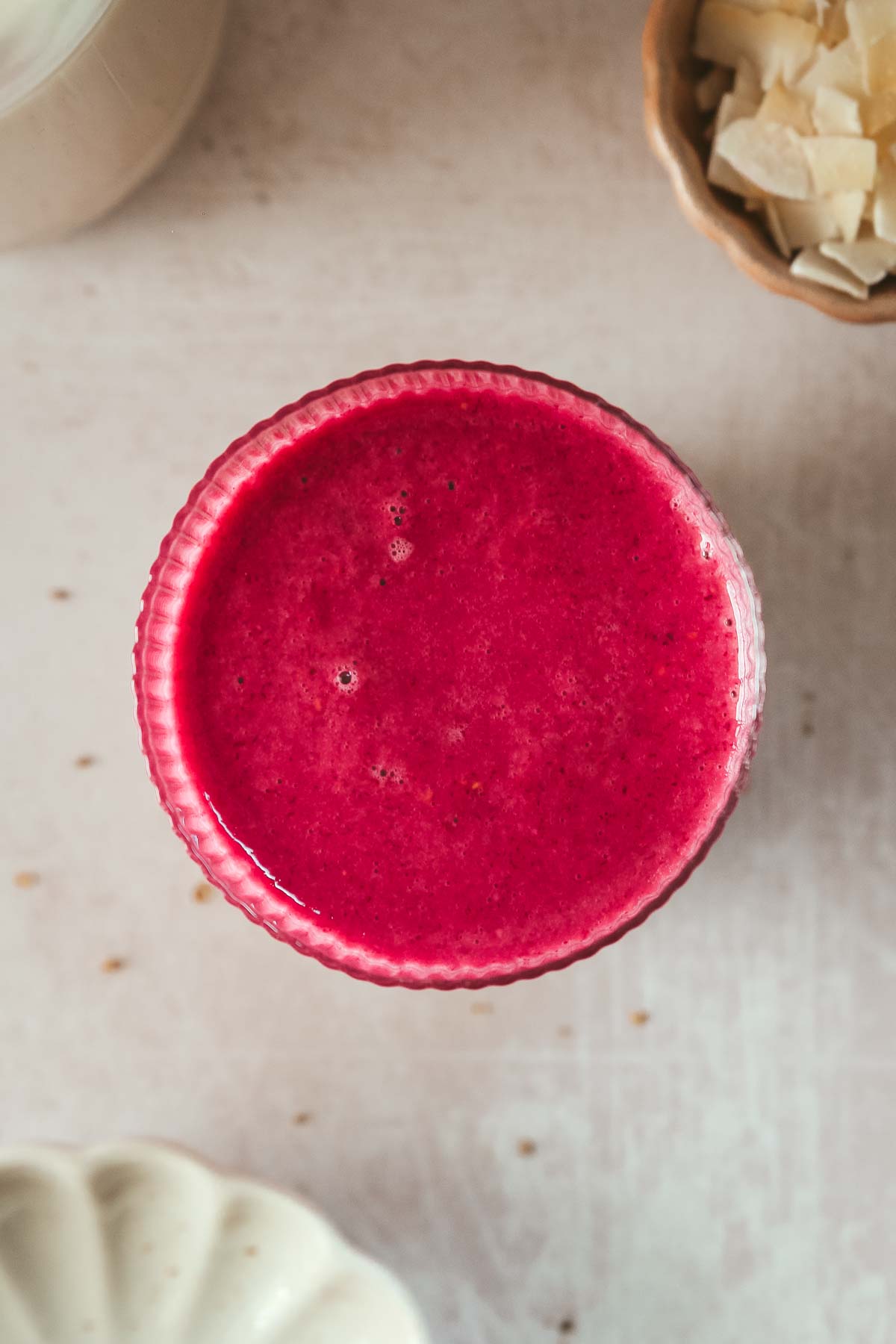 overhead shot of hot pink breakfast smoothie on beige background.