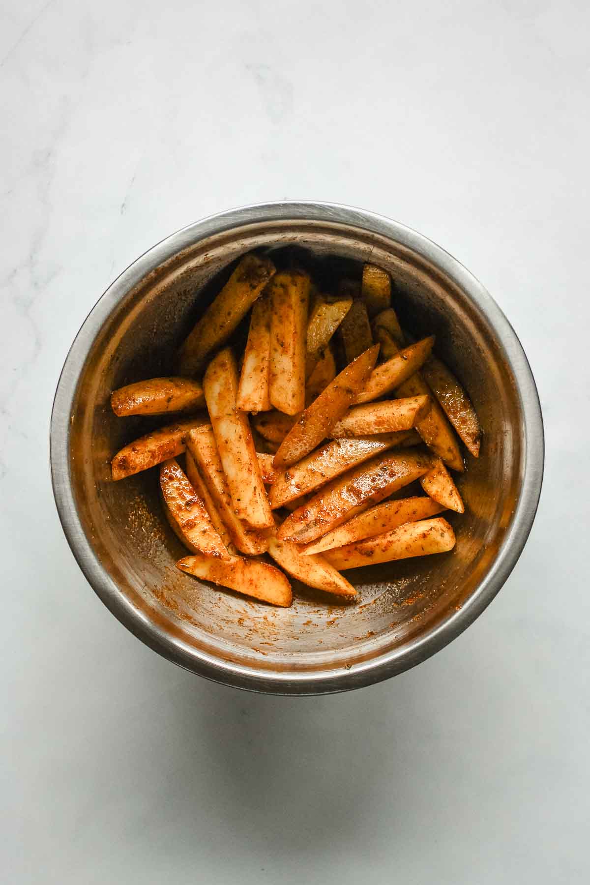 cajun seasoned fries in metal bowl.