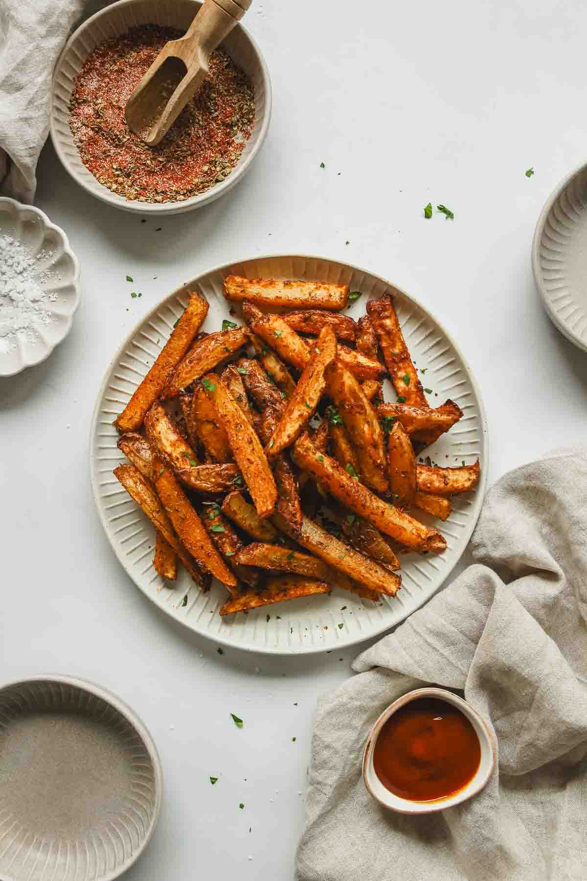 best cajun fries on white plate with parsley and ketchup.