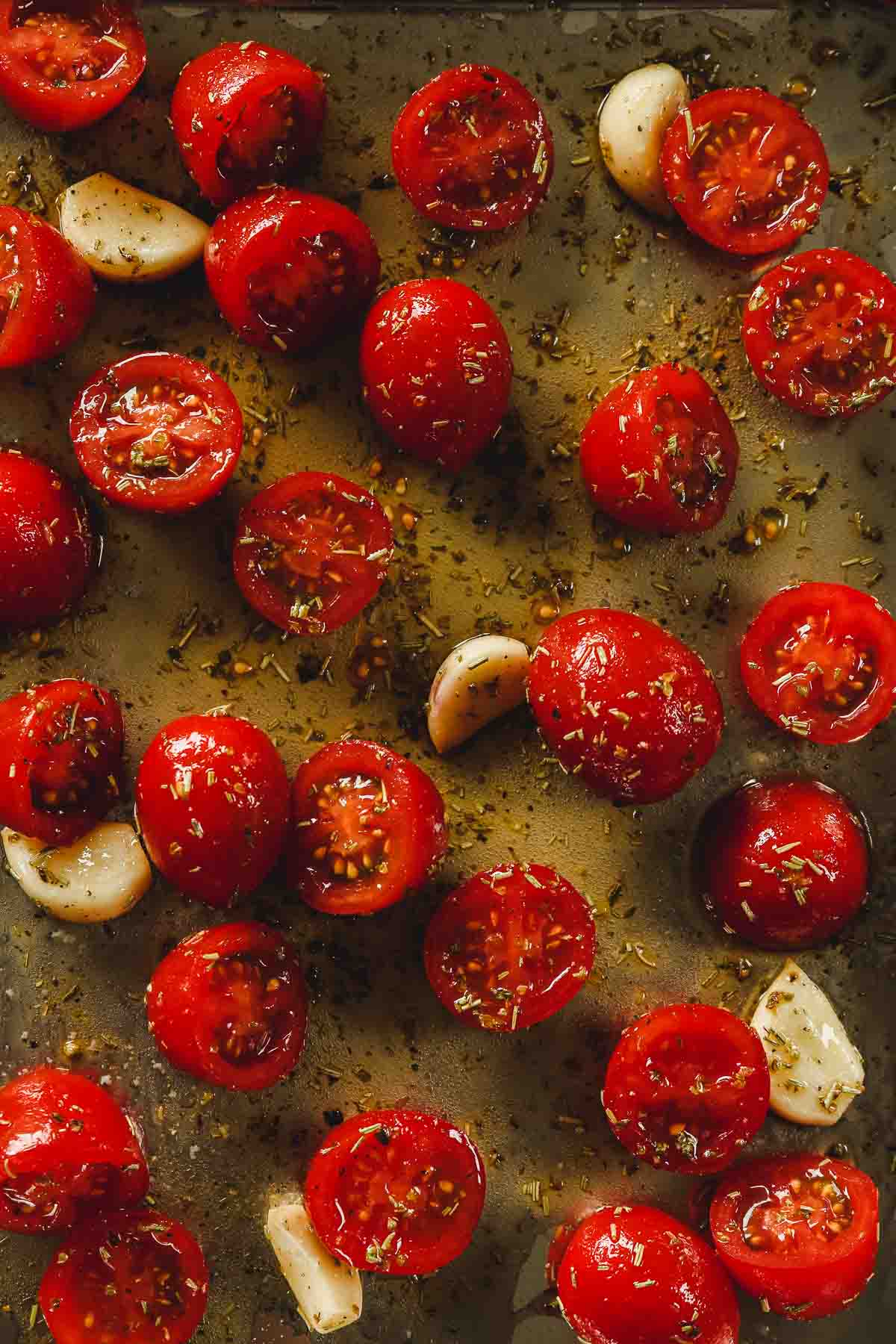 marinated cherry tomatoes and garlic on sheet pan.