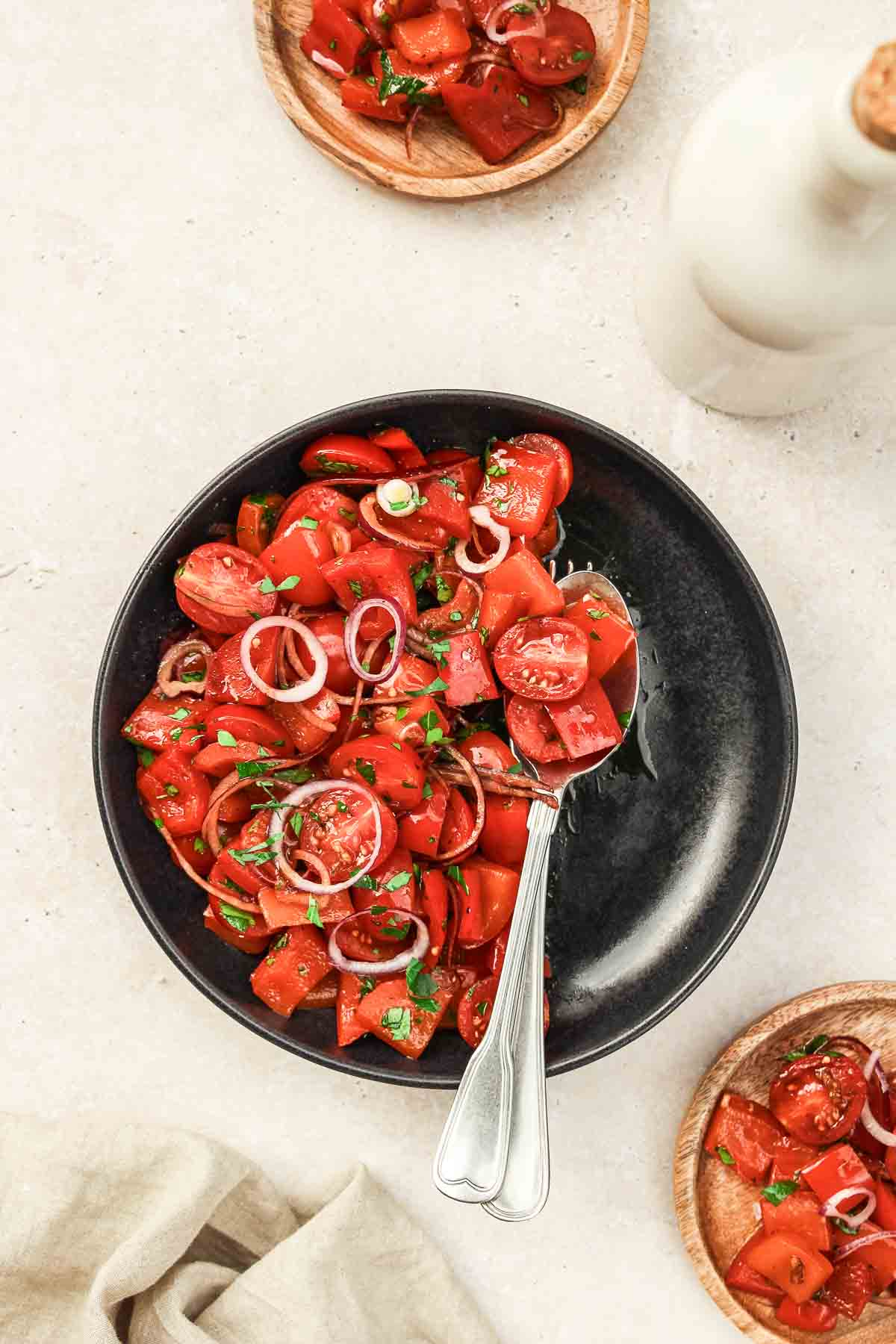 sweet pepper salad on black plate with vintage cutlery on beige background.