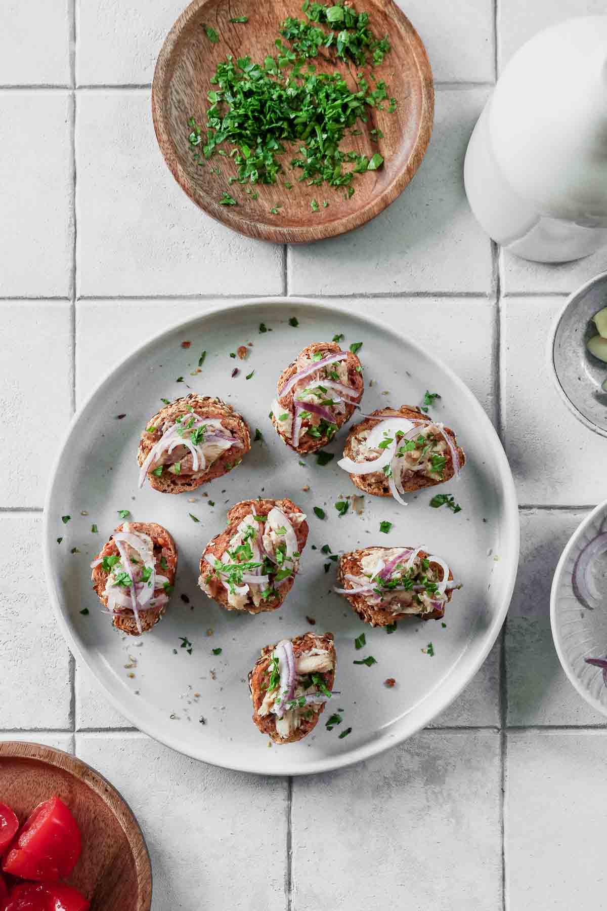 ready to serve sardines on toast with tomato and red onion.