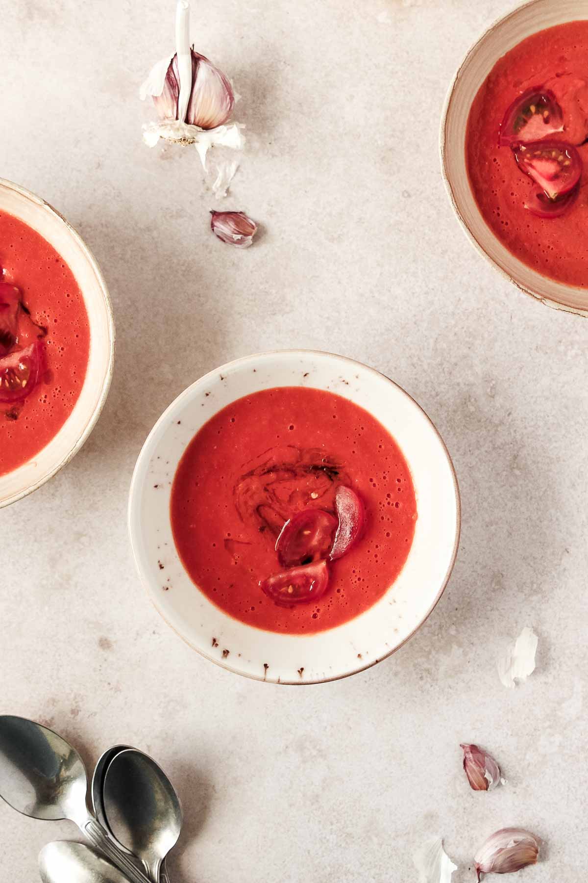 easy oven roasted tomato soup in beige bowls on beige background.