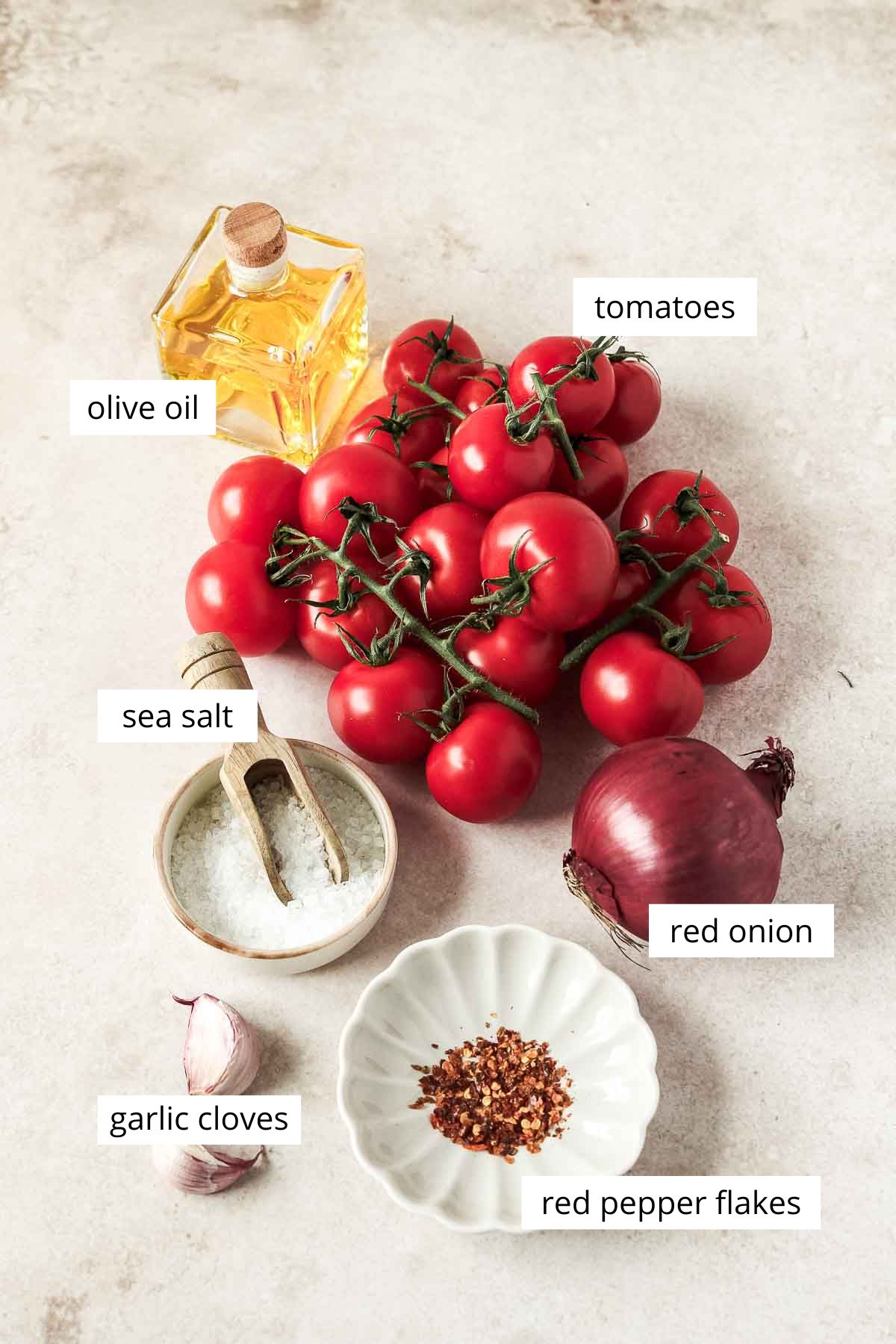 ingredients for fresh roasted tomato soup on beige background.