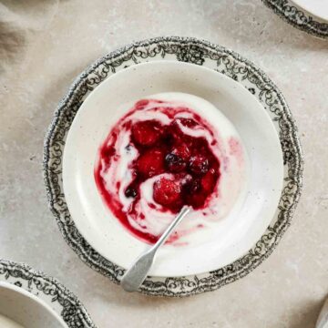 quick mixed berry compote in beige bowls on plates with flowers and vintage spoon.