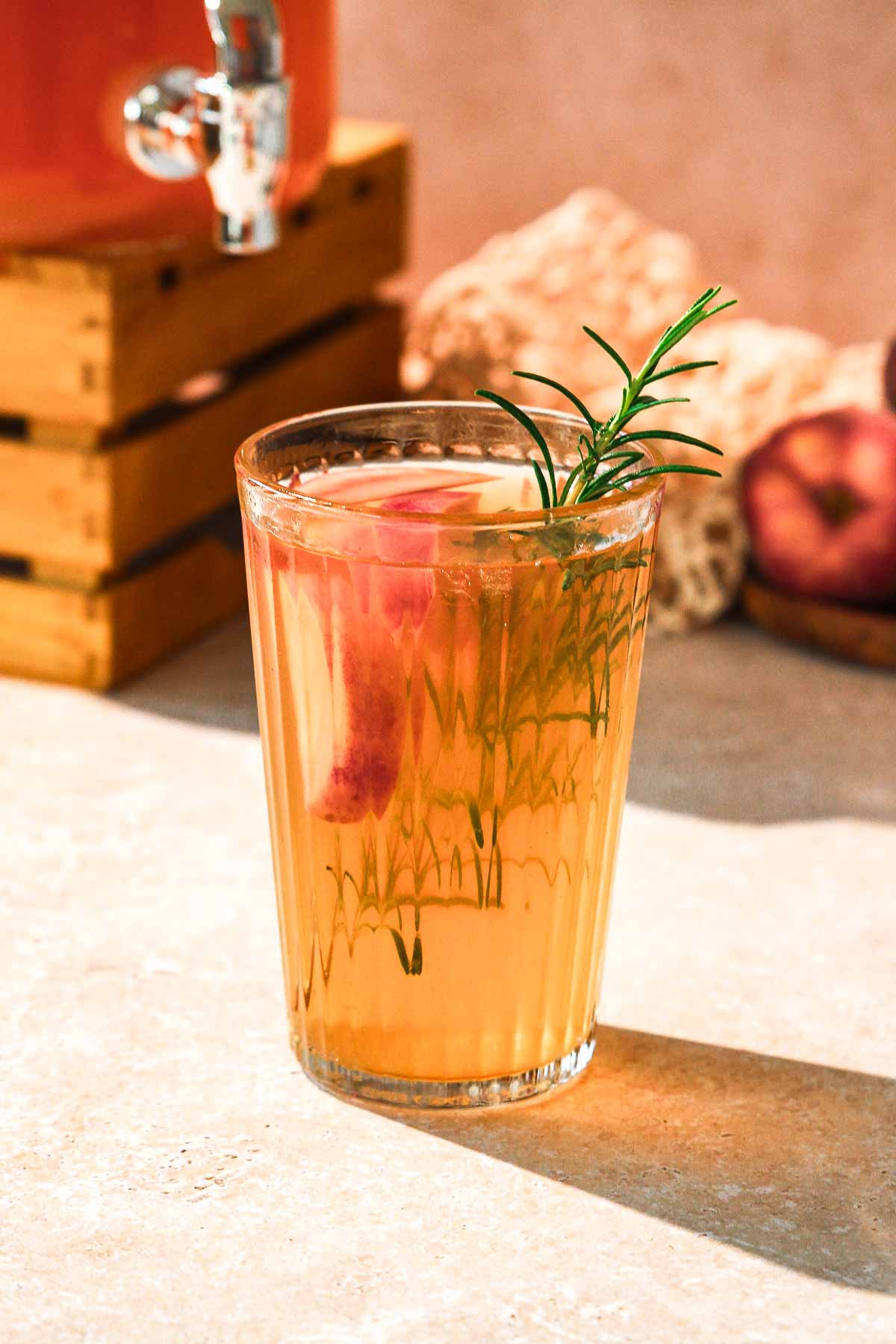 refined sugar-free peach iced tea with herb garnish on beige background.