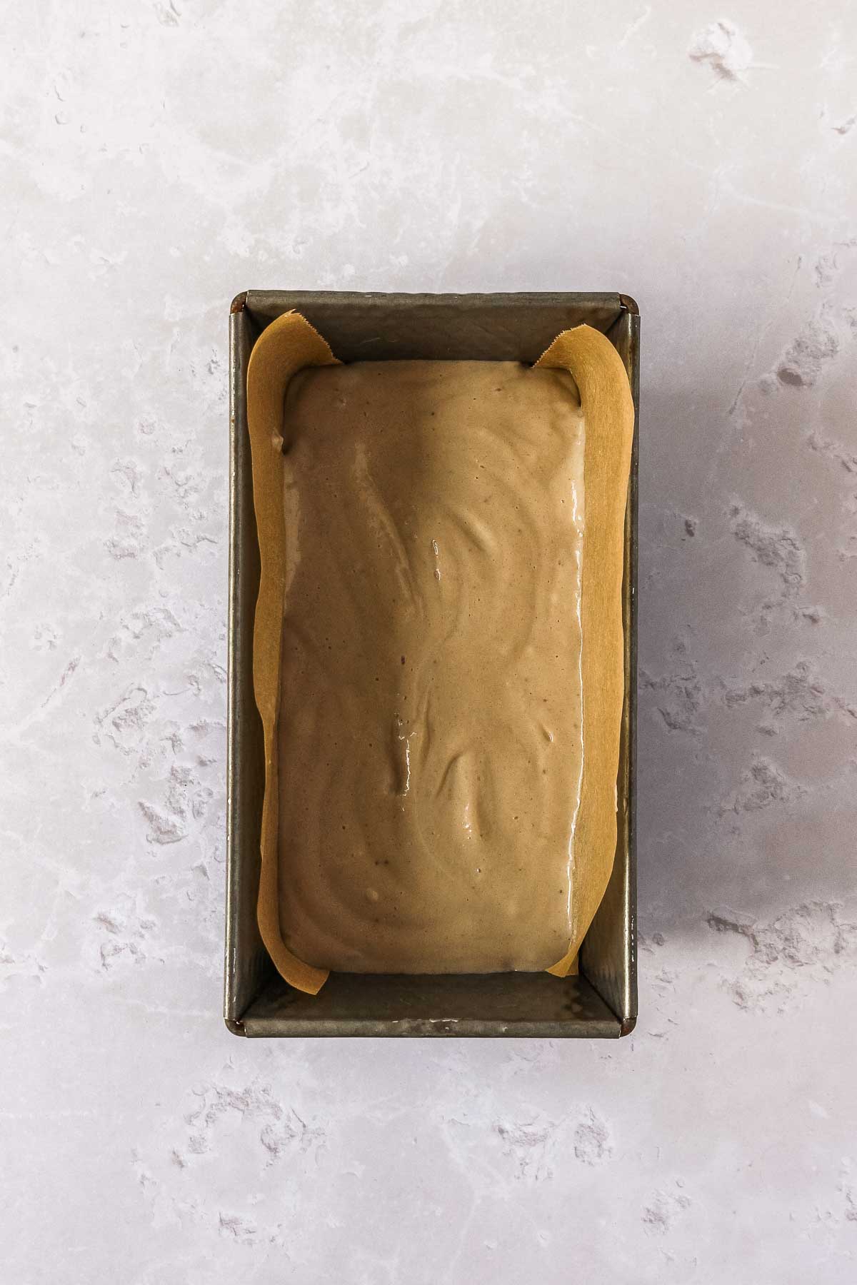 blended bananas and peanut butter in freezing pan with parchment paper.