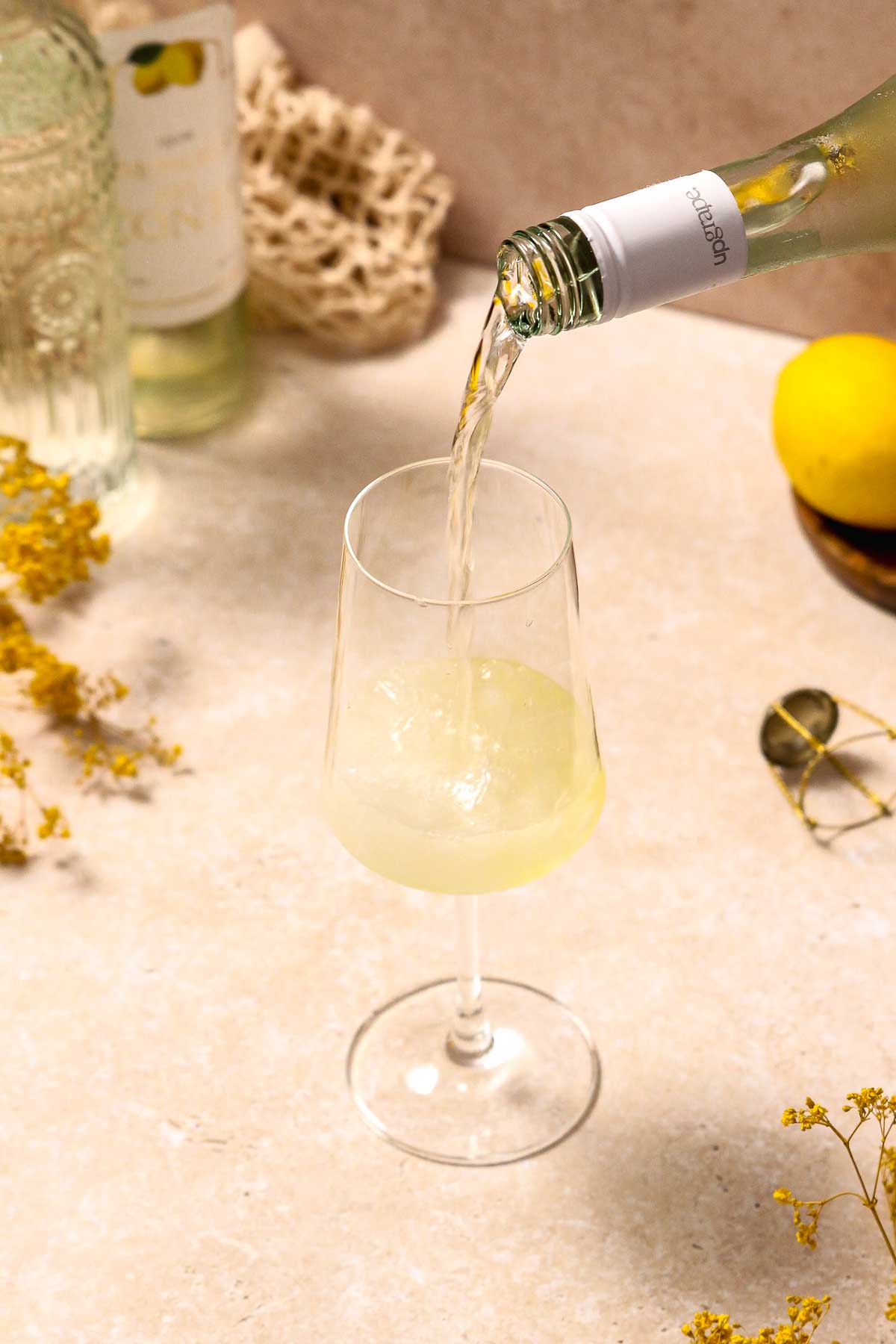 pouring sparkling wine into wine glass with crushed ice and limoncello.