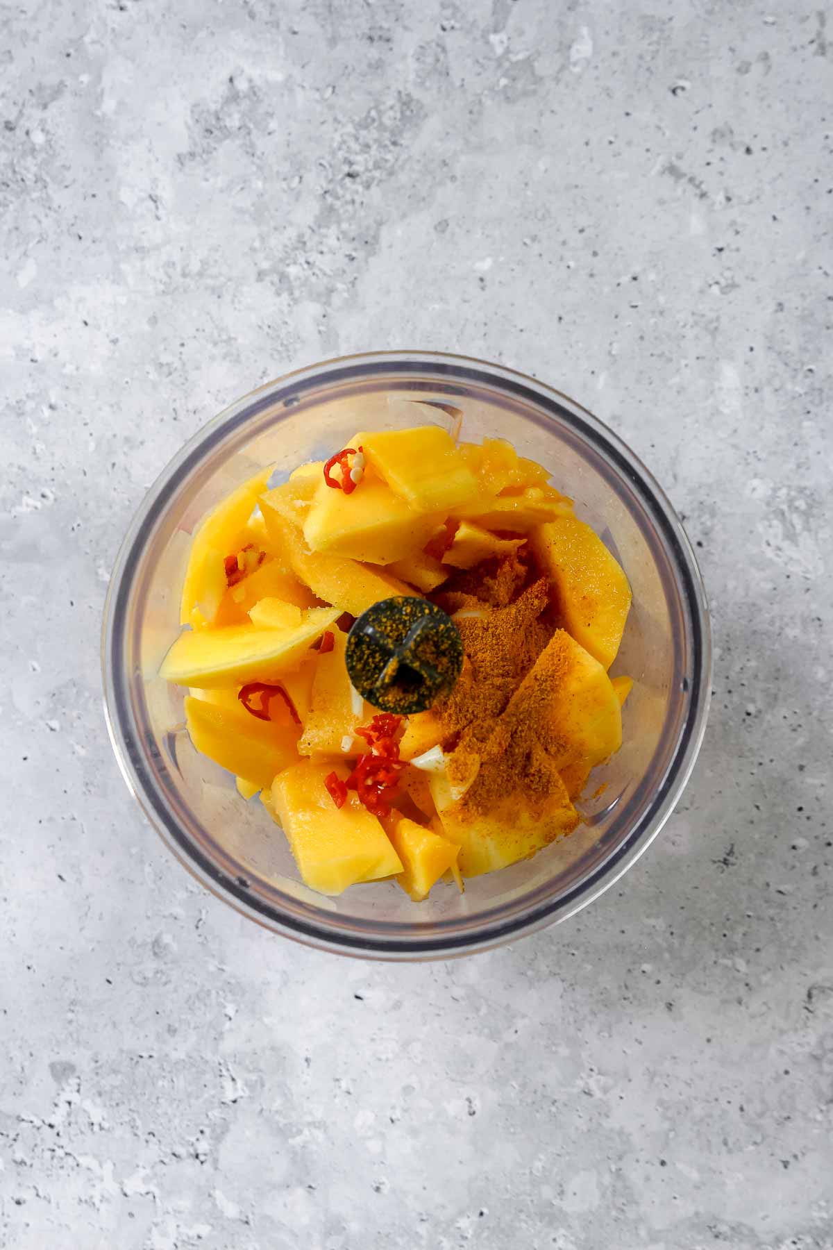 ingredients for sweet and spicy mango sauce in food processor.