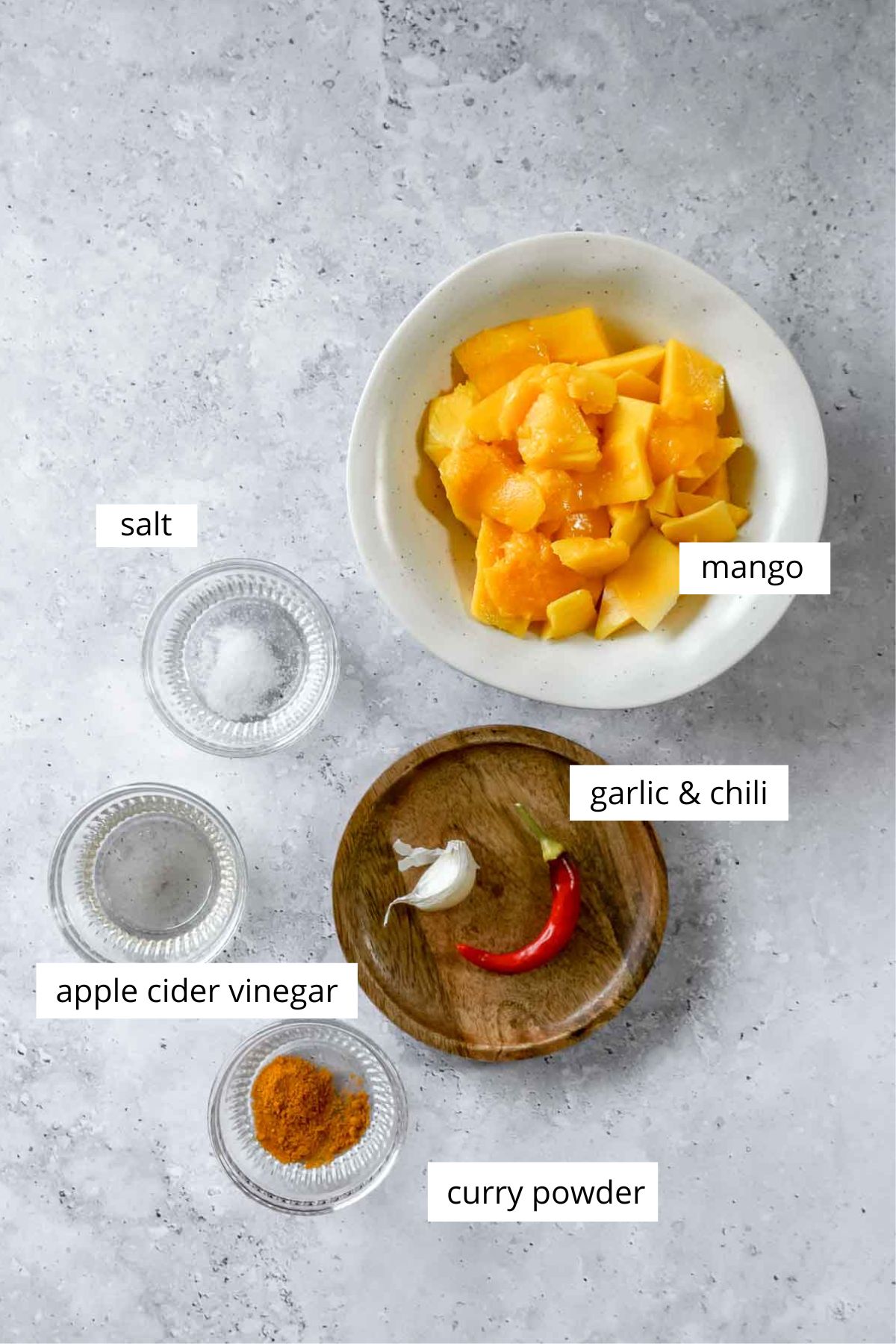 ingredients for mango hot sauce on light marble blue background.