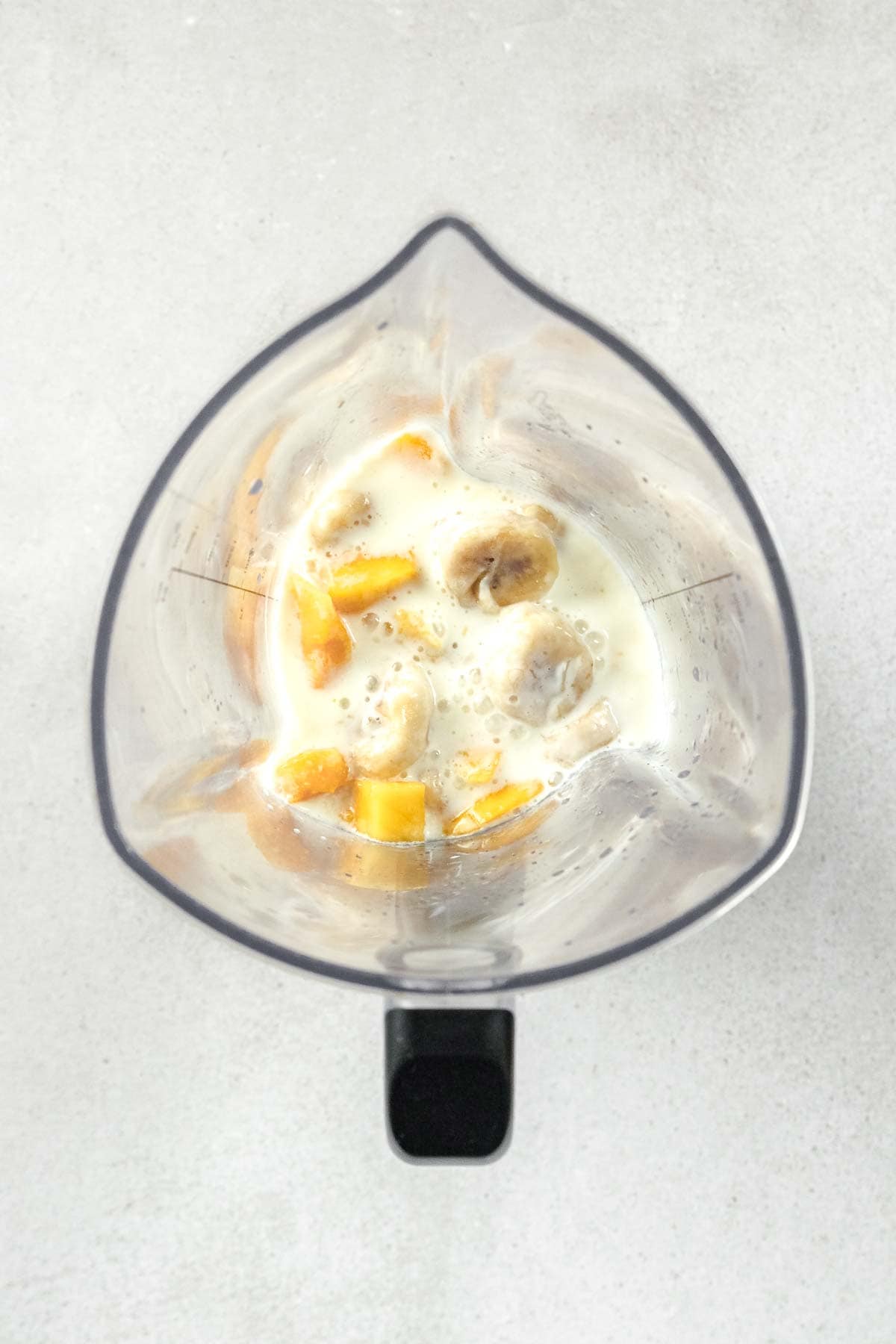 mango, banana, plant-based milk and lime juice in blender.